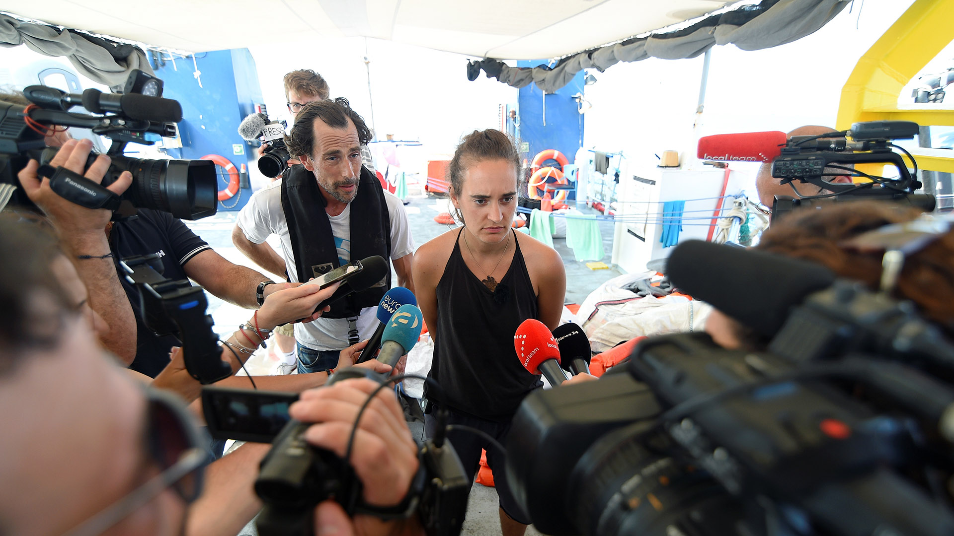 Carola Rackete, capitana del barco de rescate Sea-Watch 3, habla a los medios de comunicación mientras el barco permanece bloqueado a una milla del puerto de Lampedusa, Italia, el 27 de junio de 2019 (REUTERS/Guglielmo Mangiapane)