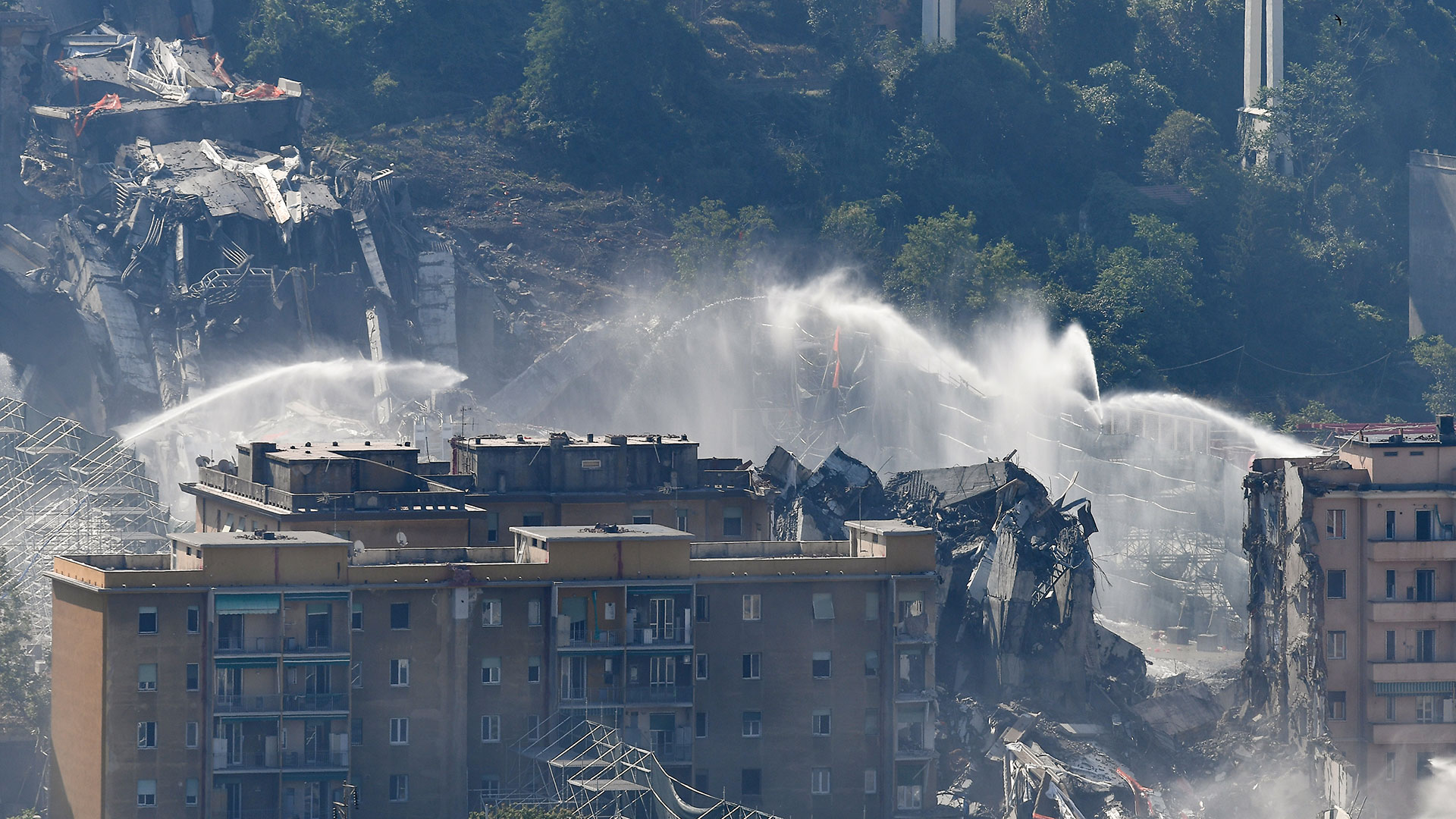 El agua se esparce sobre escombros después de que cargas explosivas volaran los pilones orientales del puente (AFP)