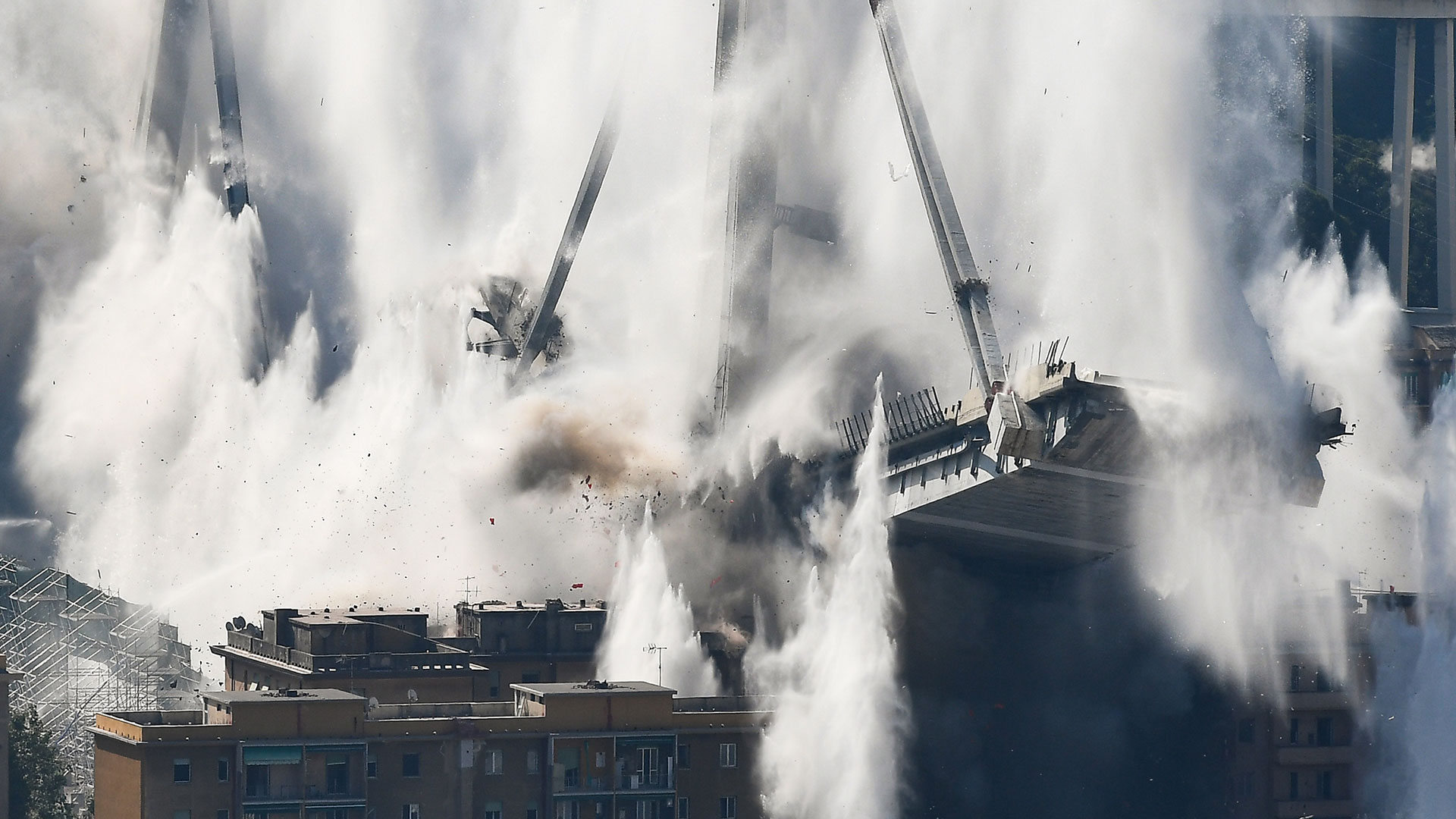 El tablero del puente se derrumba después de que cargas explosivas volaran los pilones orientales (AFP)