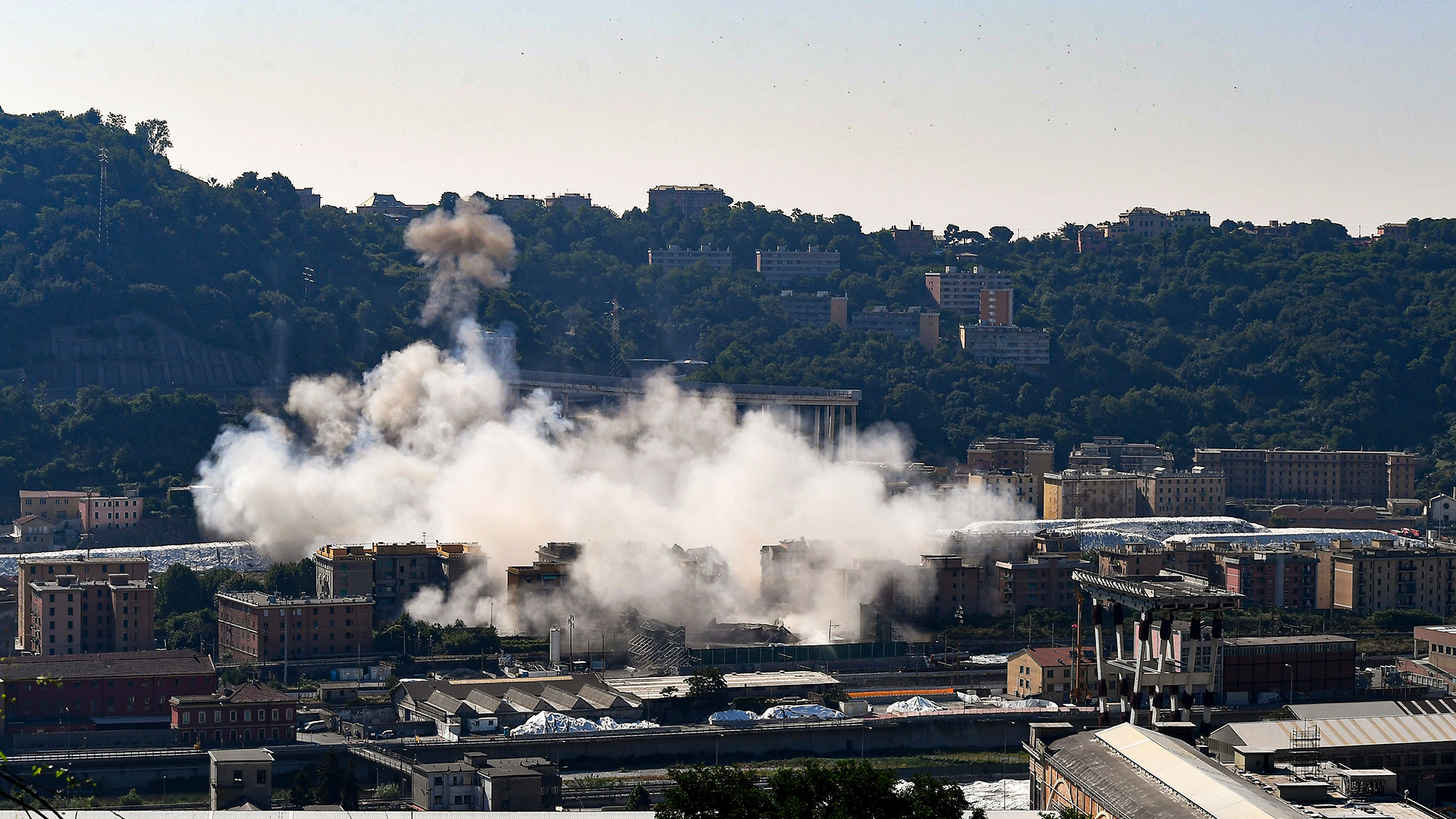 Una nube de humo cubre el lugar después de que cargas explosivas volaran lo que quedaba del puente (AFP)