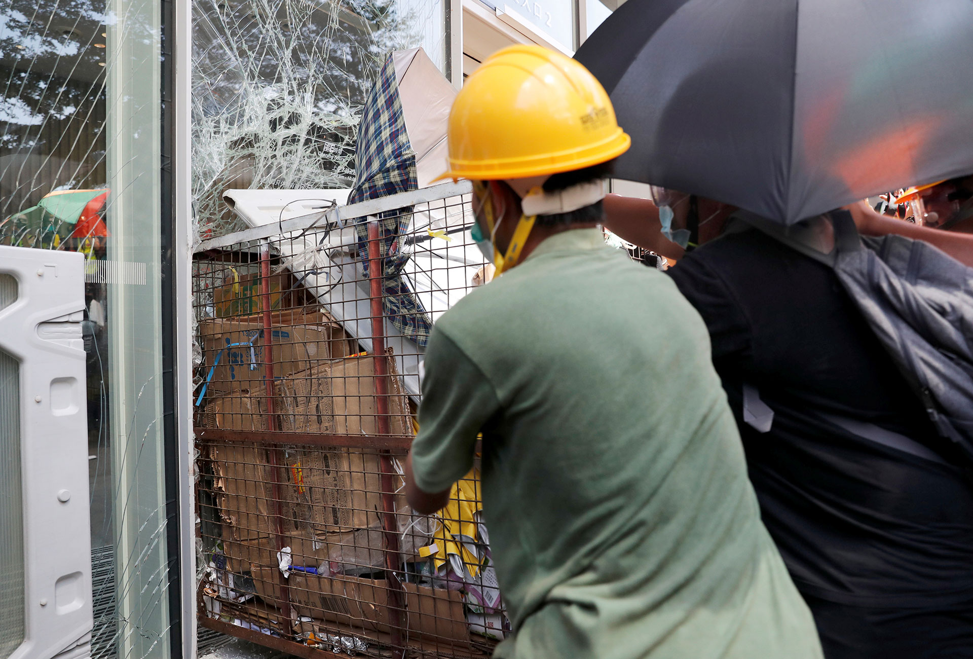 Los manifestantes intentan irrumpir en el edificio del Consejo Legislativo donde se ve a la policía antidisturbios. (Reuters / Tyrone Siu)