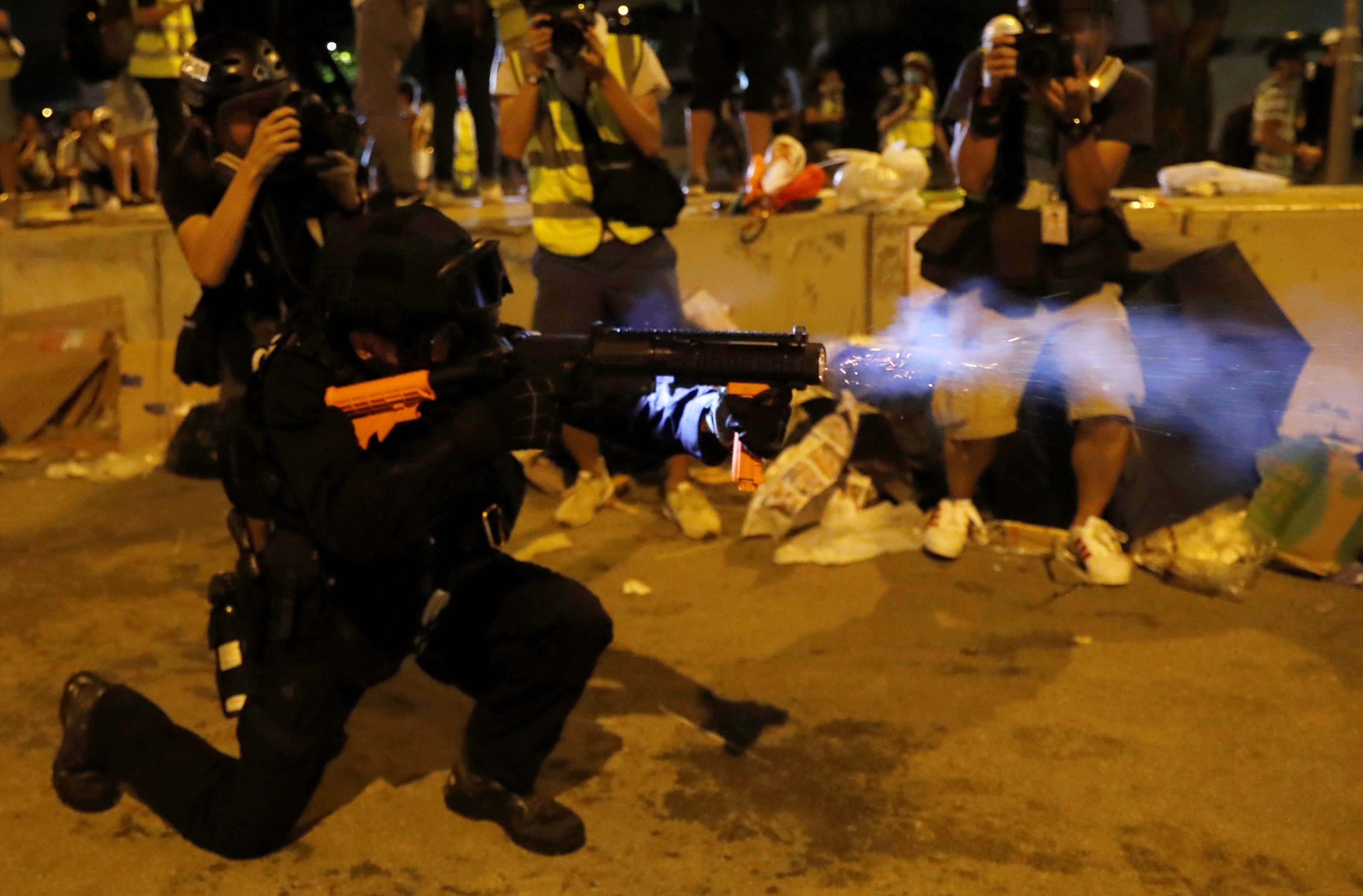 Un agente de la Policía lanza una granada de gas lacrimógeno en las adyacencias del edificio de la Legislatura para dispersar a los manifestantes