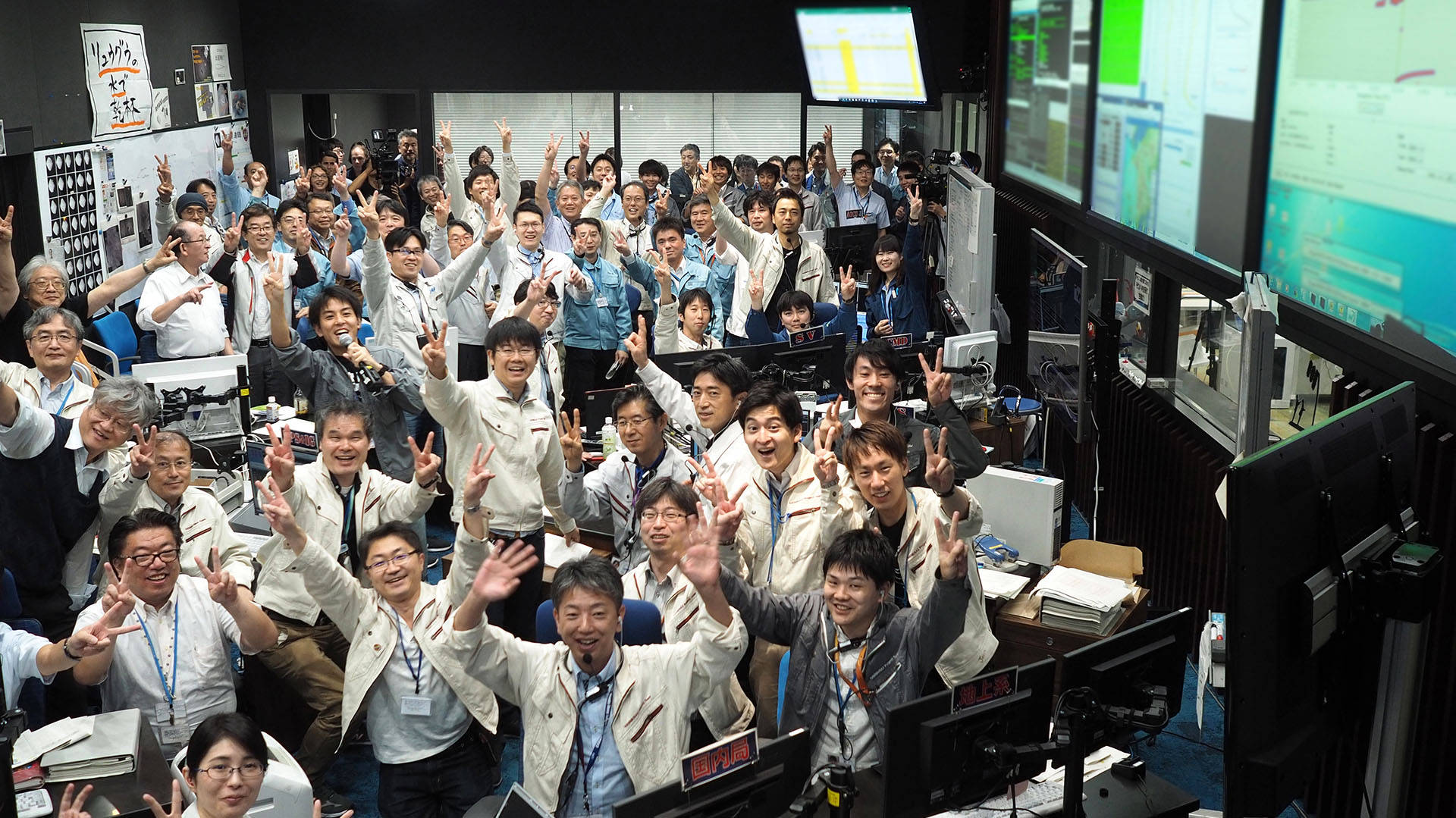 Esta fotografía del 11 de julio muestra a investigadores y empleados celebrando después de recibir la confirmación del aterrizaje de Hayabusa 2 en el asteroide Ryugu, en la sala de control de la misión en la ciudad de Sagamihara, prefectura de Kanagawa (Foto de Yutaka IIJIMA / ISAS-JAXA / AFP)
