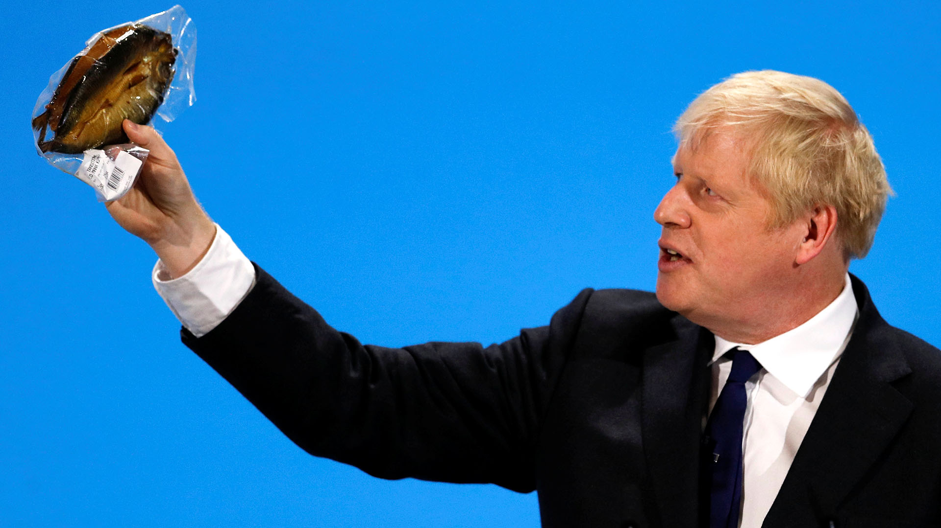 Johnson sostiene un arenque envuelto en plástico durante un evento de campaña en Londres, el 17 de julio de 2019 (REUTERS/Peter Nicholls)