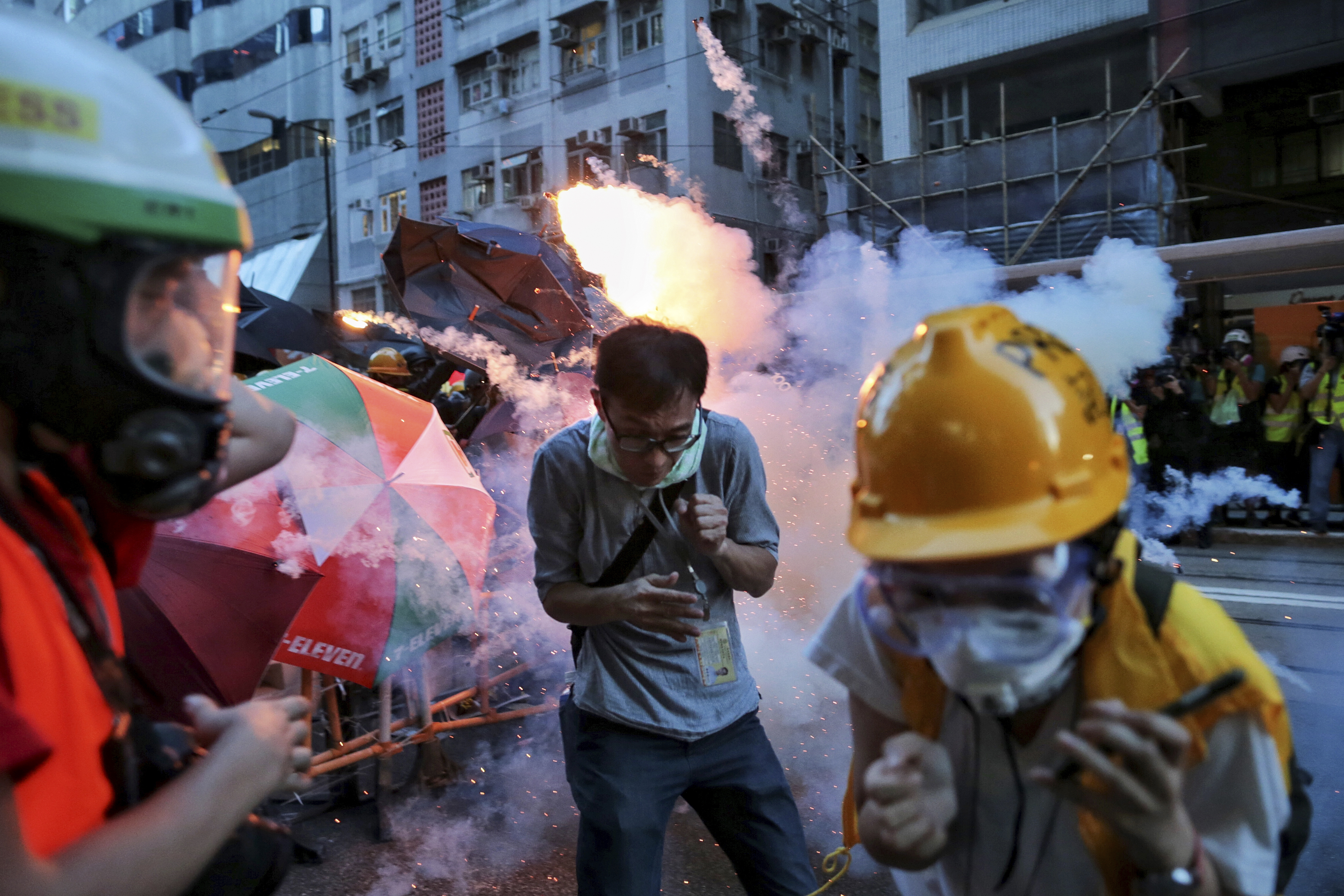 Manifestantes huyen de los gases lacrimógenos que dispara la policía en Hong Kong (Elson Li/ HK01 vía AP)