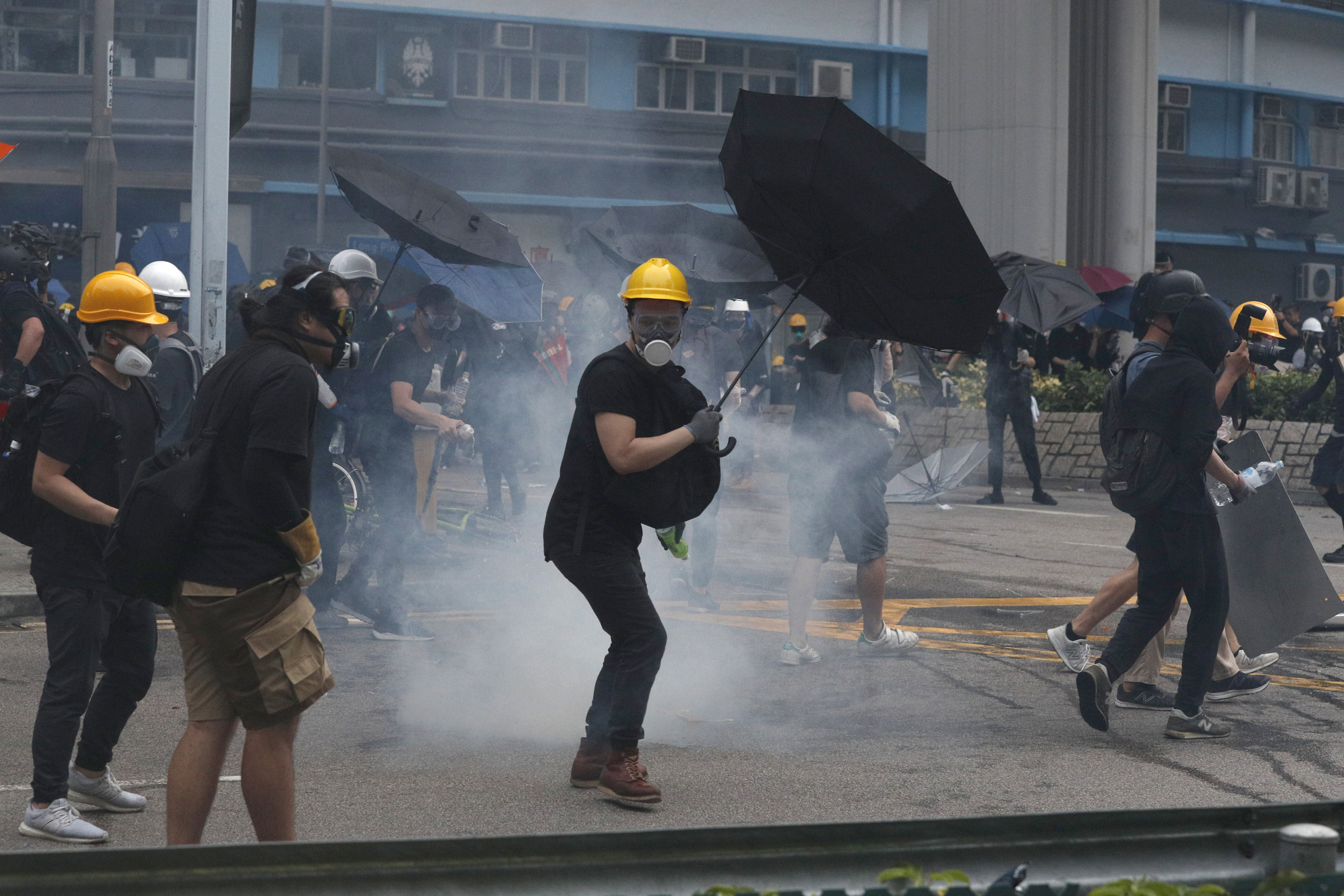 Manifestantes devuelven granadas de gas lacrimógeno lanzadas por la policía durante un enfrentamiento en el distrito de Yuen Long, Hong Kong, sábado 27 de julio de 2019 (AP Photo/ Bobby Yip)