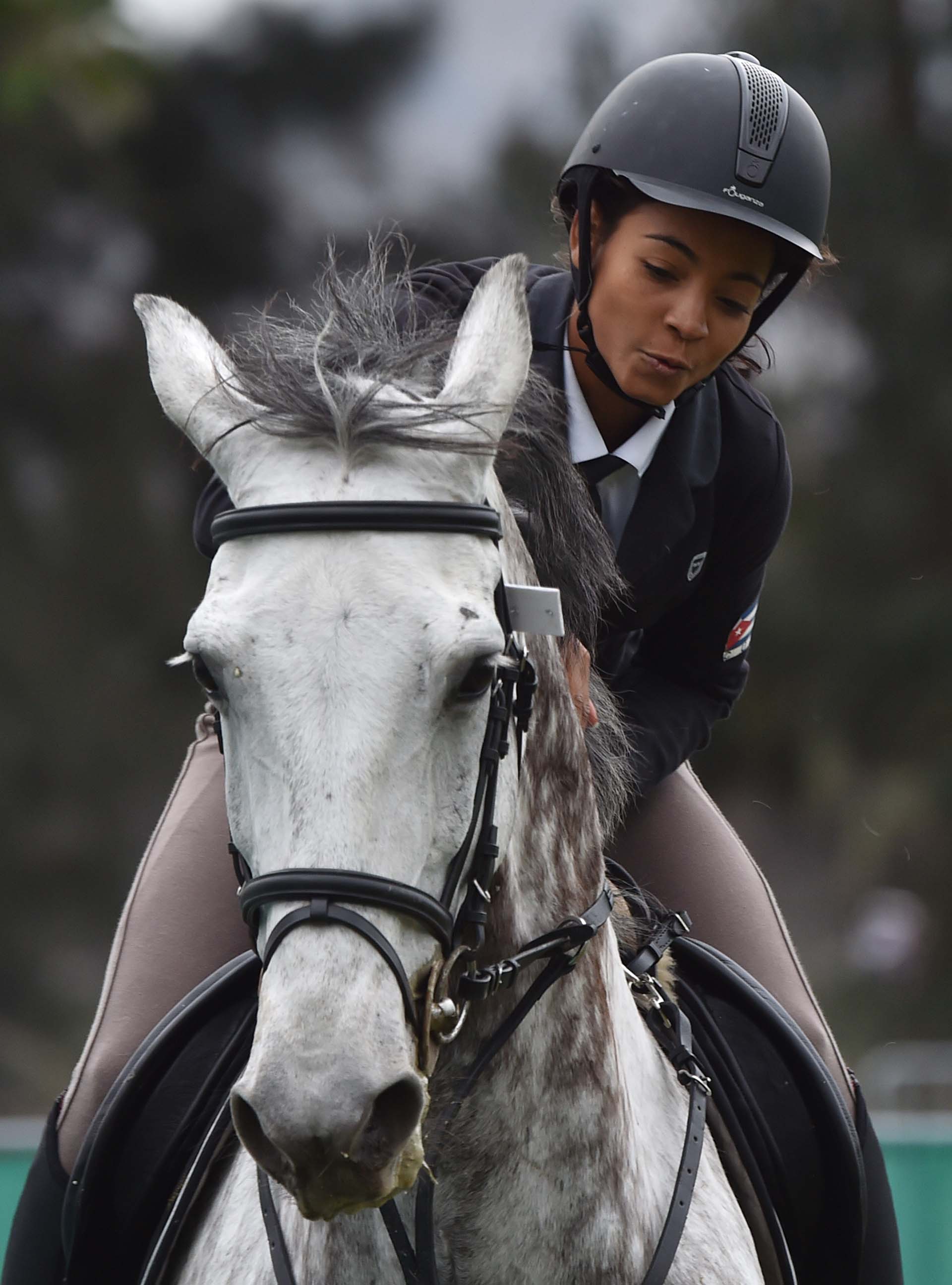 La cubana Eliani Camara parece dialogar con su caballo. (Photo by Cris BOURONCLE / AFP)