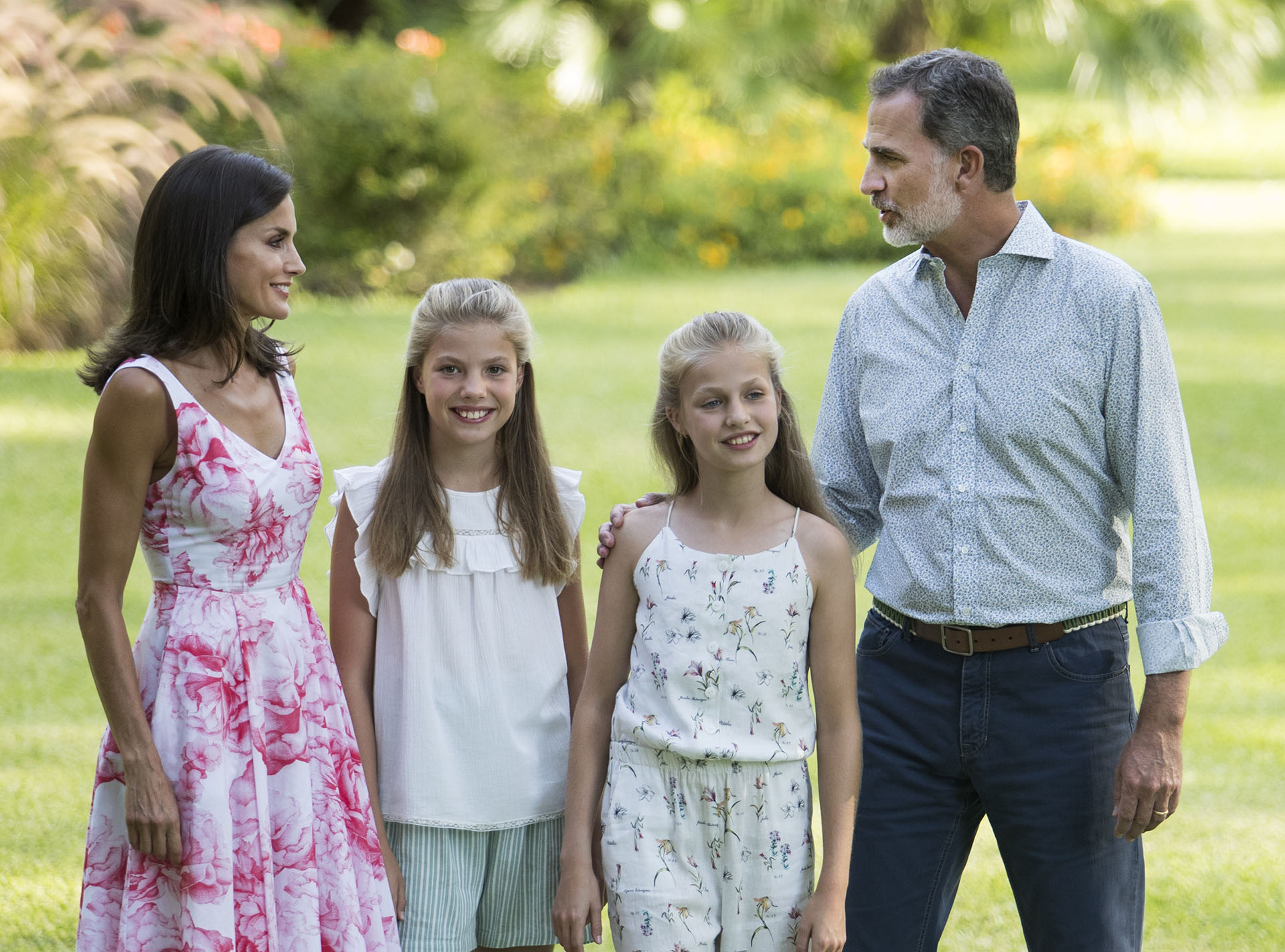 Postal completa, la reina Letizia, el rey Felipe y sus hijas, Leonor y Sofía en los jardínes del Palacio Marivent