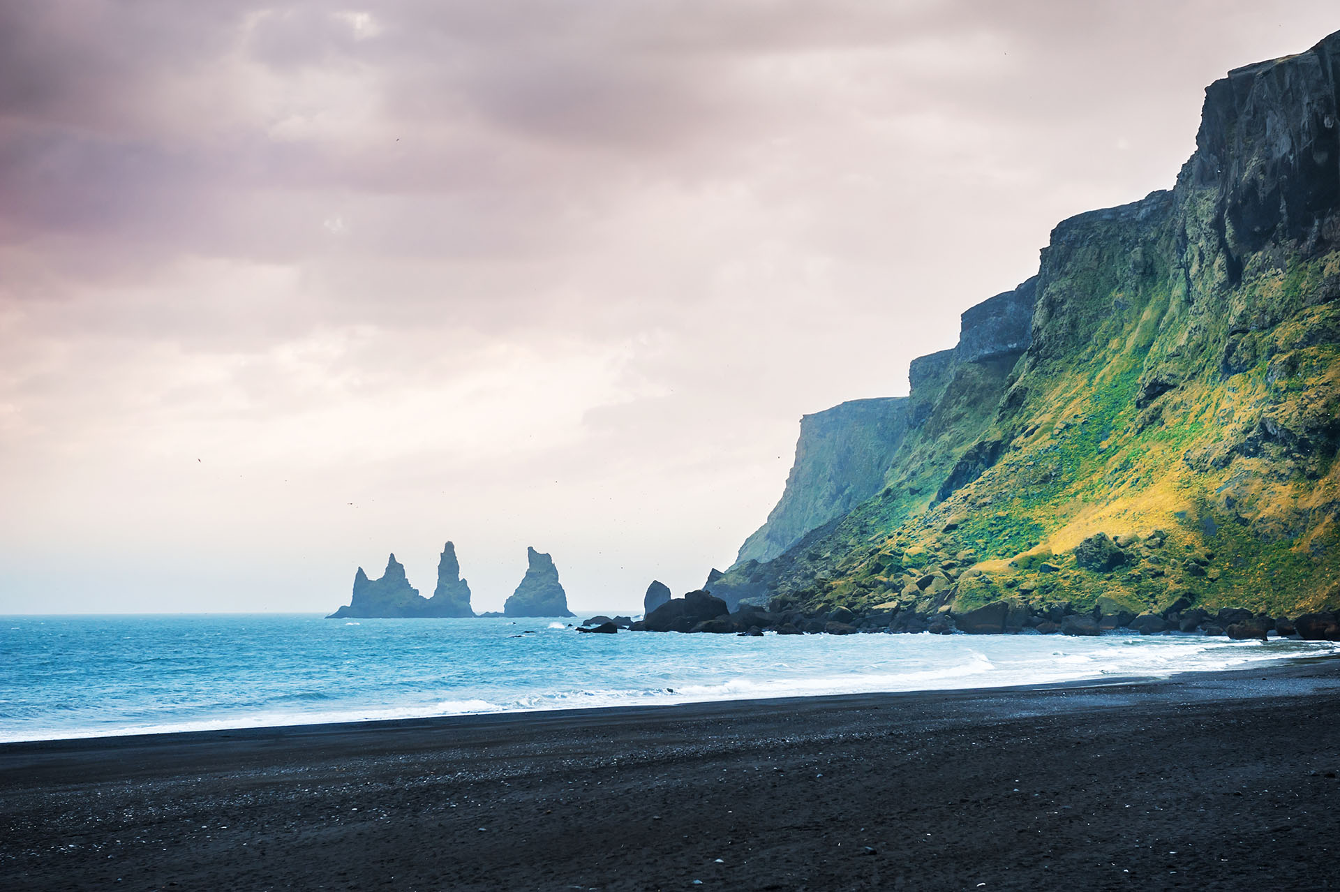 Opuesto a las playas tropicales, esta hermosa playa de arena negra en Islandia es única en el mundo, con enormes pilas de basalto que se levantan del mar y arena negra inusual