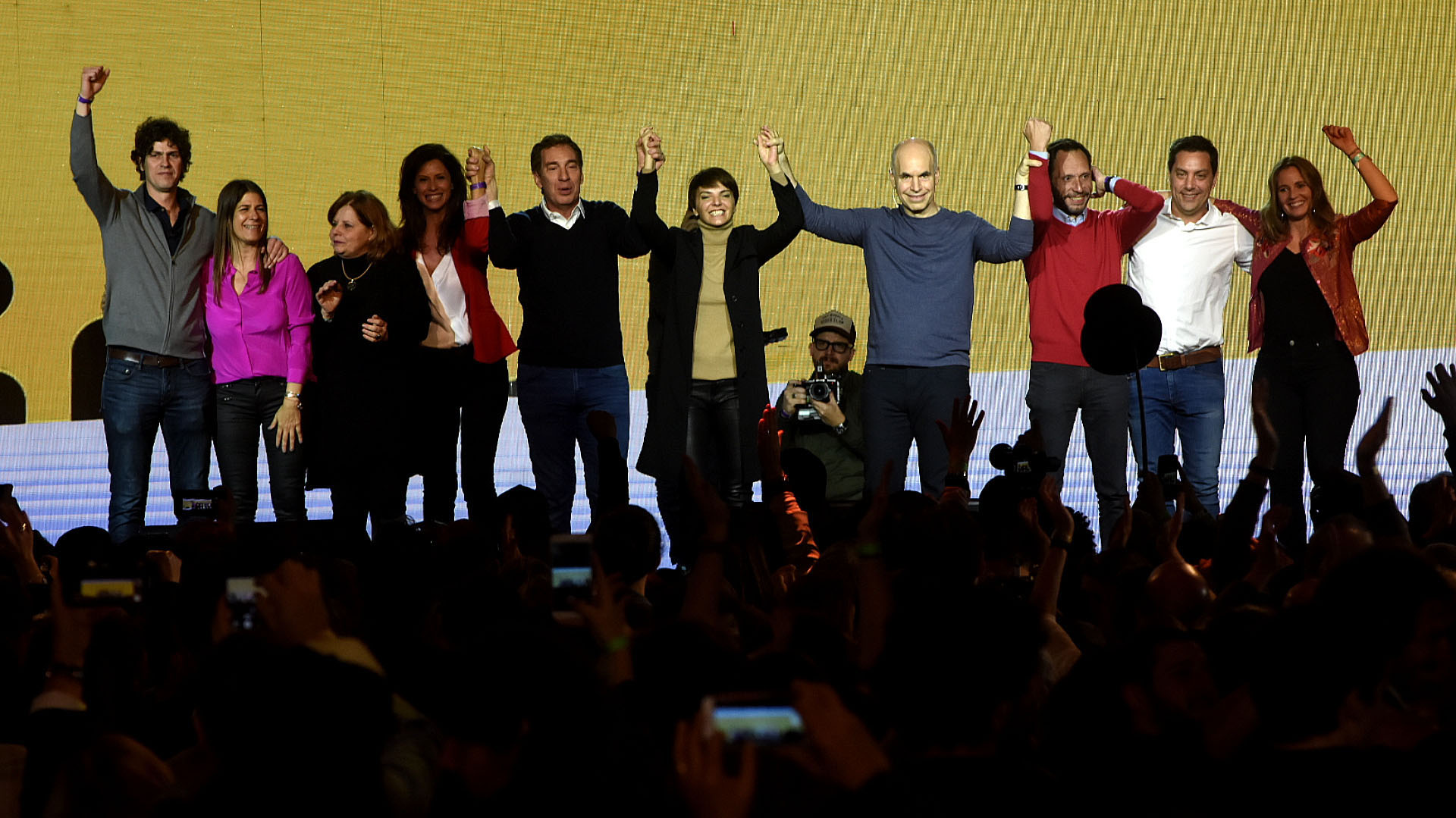Acompañado por su esposa, Bárbara Diez que lució calzas engomadas, un maxi tapado negro y polera beige. El equipo de Juntos por el Cambio estuvo compuesto también por Diego Santilli de sweater y camisa y Analía Maiorana con blazer rojo y pantalón negro