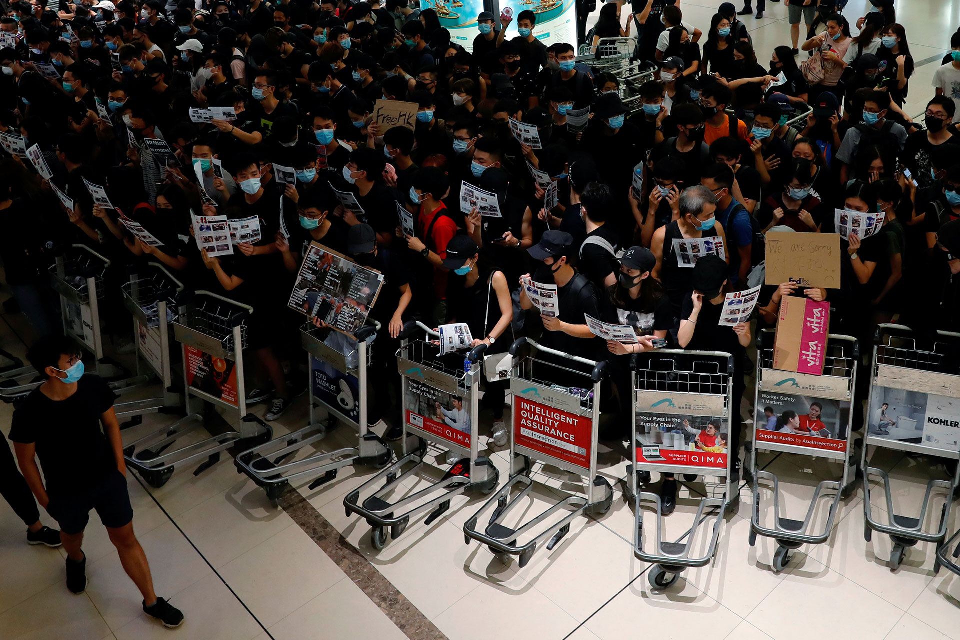 Los movilizados impiden que los pasajeros entren al aeropuerto por las puertas de seguridad (REUTERS/Tyrone Siu).