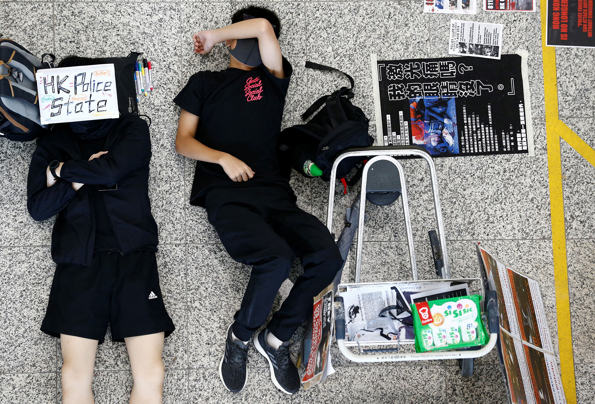 Dos jóvenes manifestantes antigubernamentales duermen en el suelo del aeropuerto de Hong Kong (REUTERS/Thomas Peter)