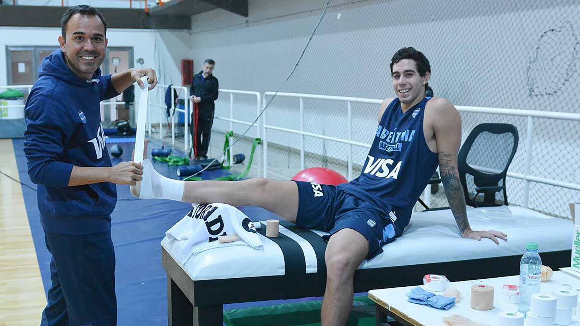 Paulo Maccari realizándole un vendaje a Luca Vildoza, uno de los bases del plantel de Sergio Hernández (@maccarisports)