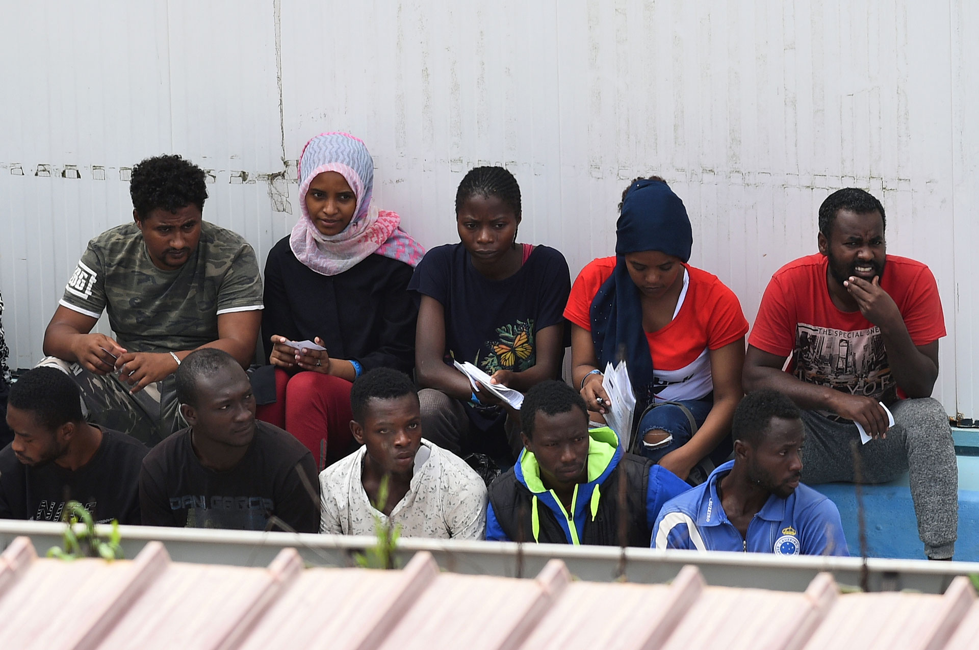 Tras el desembarco, el martes a la noche, algunos de los migrantes son vistos en el centro de inmigración de la meridional isla siciliana de Lampedusa (REUTERS/Guglielmo Mangiapane)