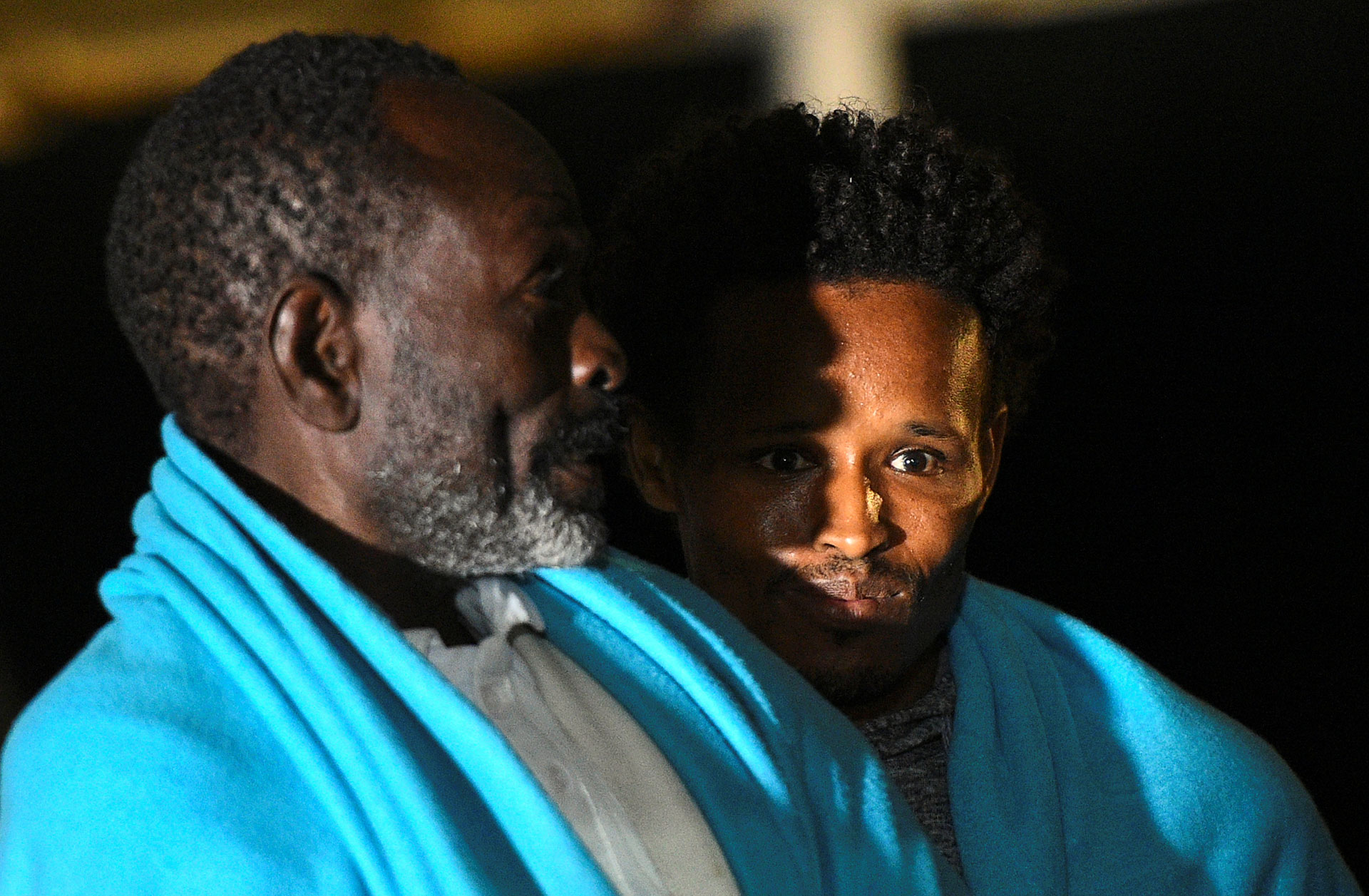 Dos hombres observan el muelle tras el arribo del barco (REUTERS/Guglielmo Mangiapane)