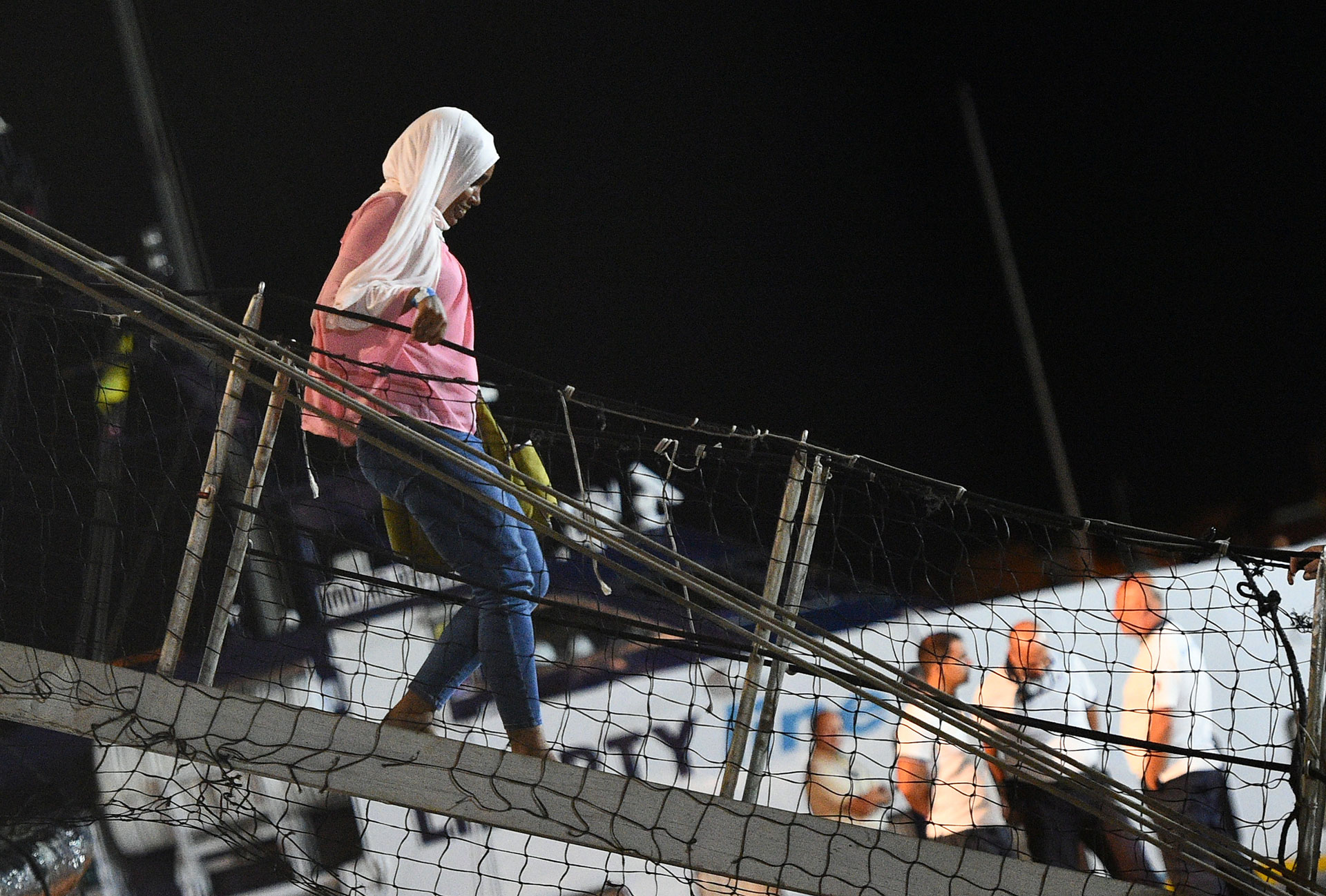 Una migrante desembarca del Open Arms el 20 de agosto a la noche (REUTERS/Guglielmo Mangiapane)