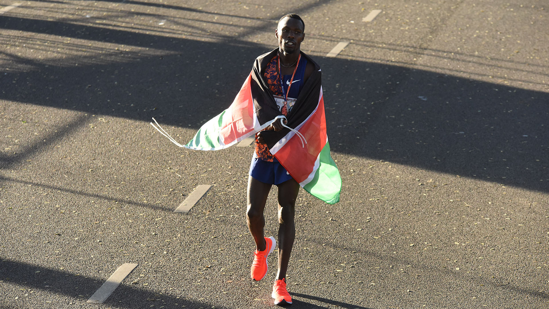 El ganador de la carrera, envuelto en la bandera de su país natal