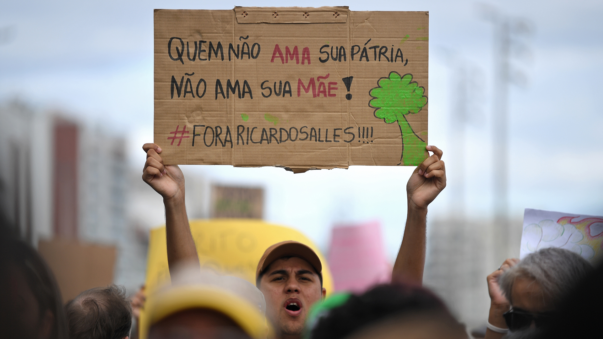 Un activista sostiene un cartel que dice “Aquel que no ama a su patria, no ama a su madre” durante la protesta. (Foto por Mauro PIMENTEL / AFP)