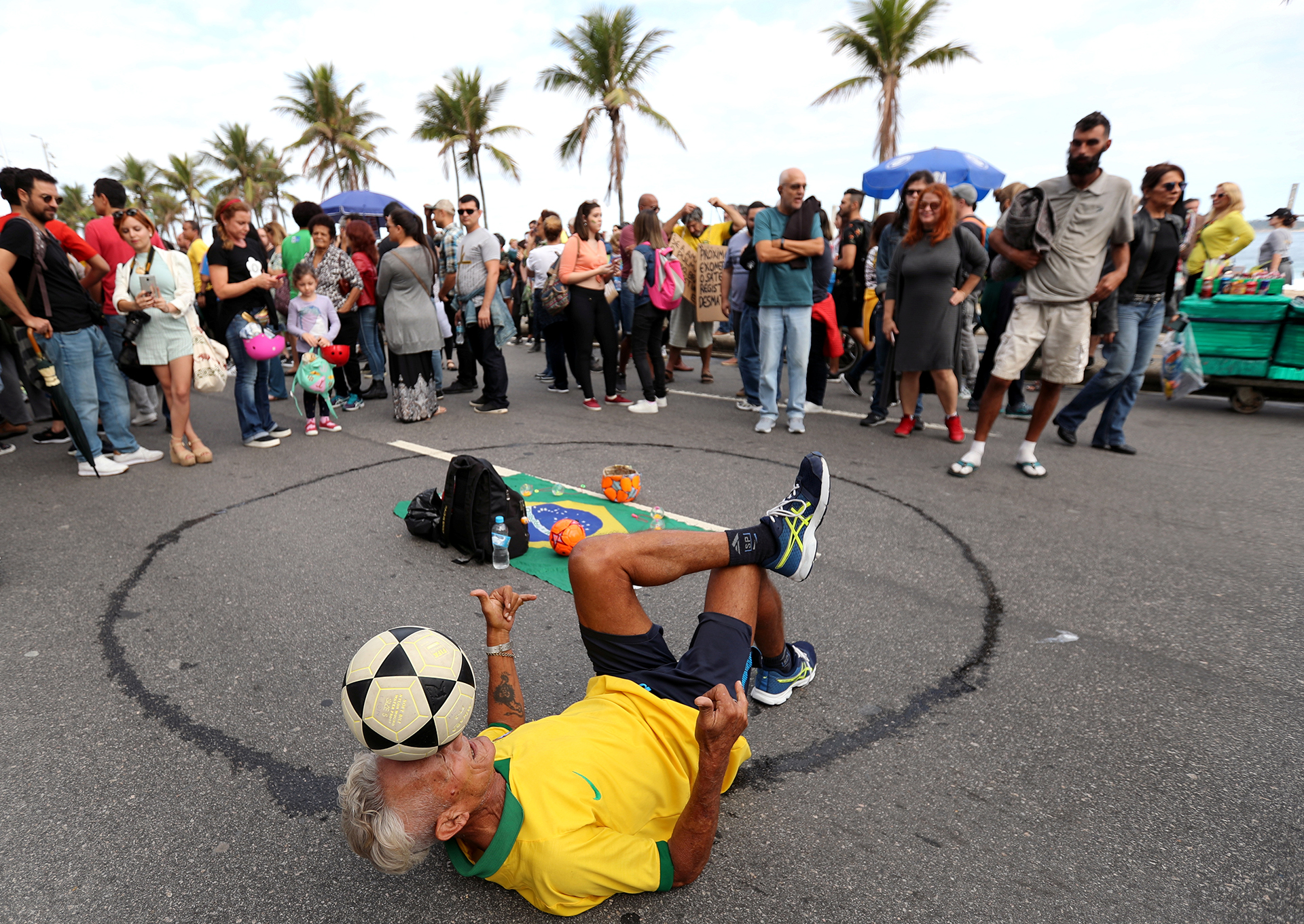 Un hombre juega con una pelota de fútbol durante la manifestación. REUTERS / Sergio Moraes