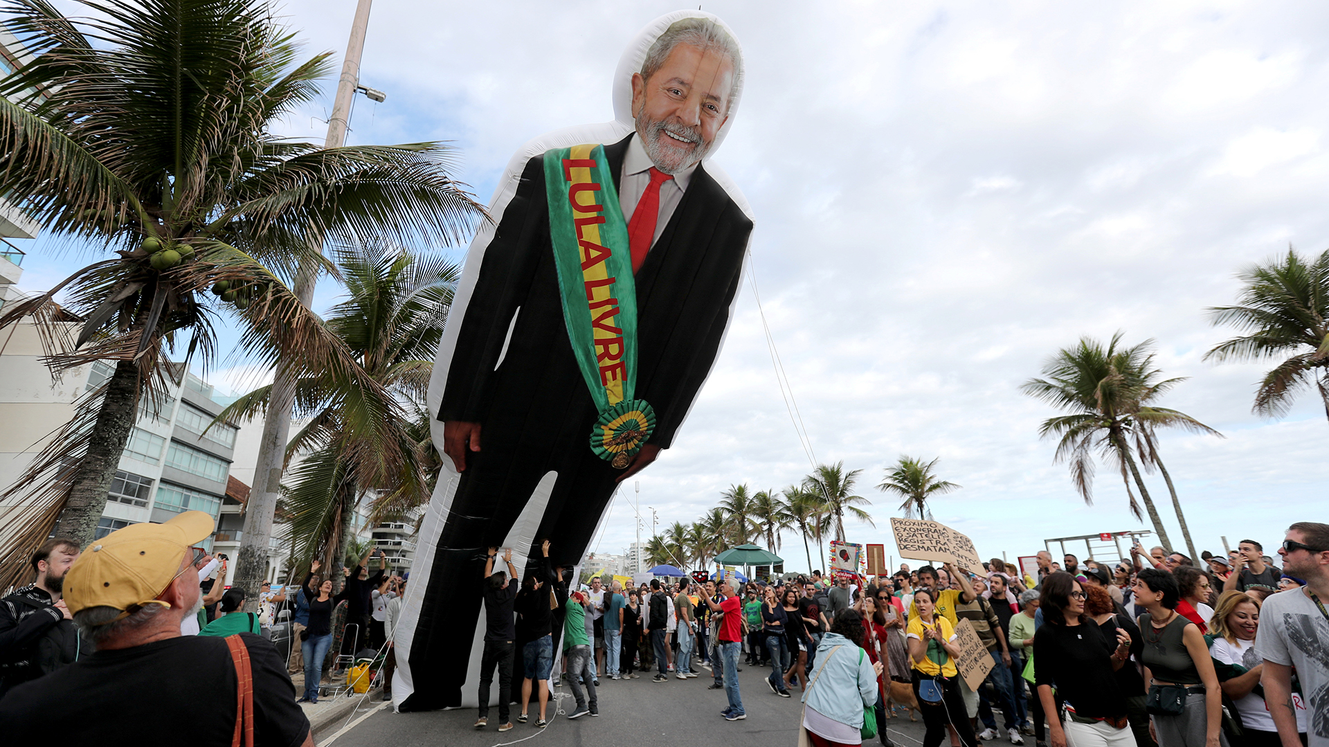 La gente sostiene una muñeca inflable del ex presidente brasileño Luiz Inácio Lula da Silva antes de la manifestación. La faja dice “Liberen a Lula”. REUTERS / Sergio Moraes