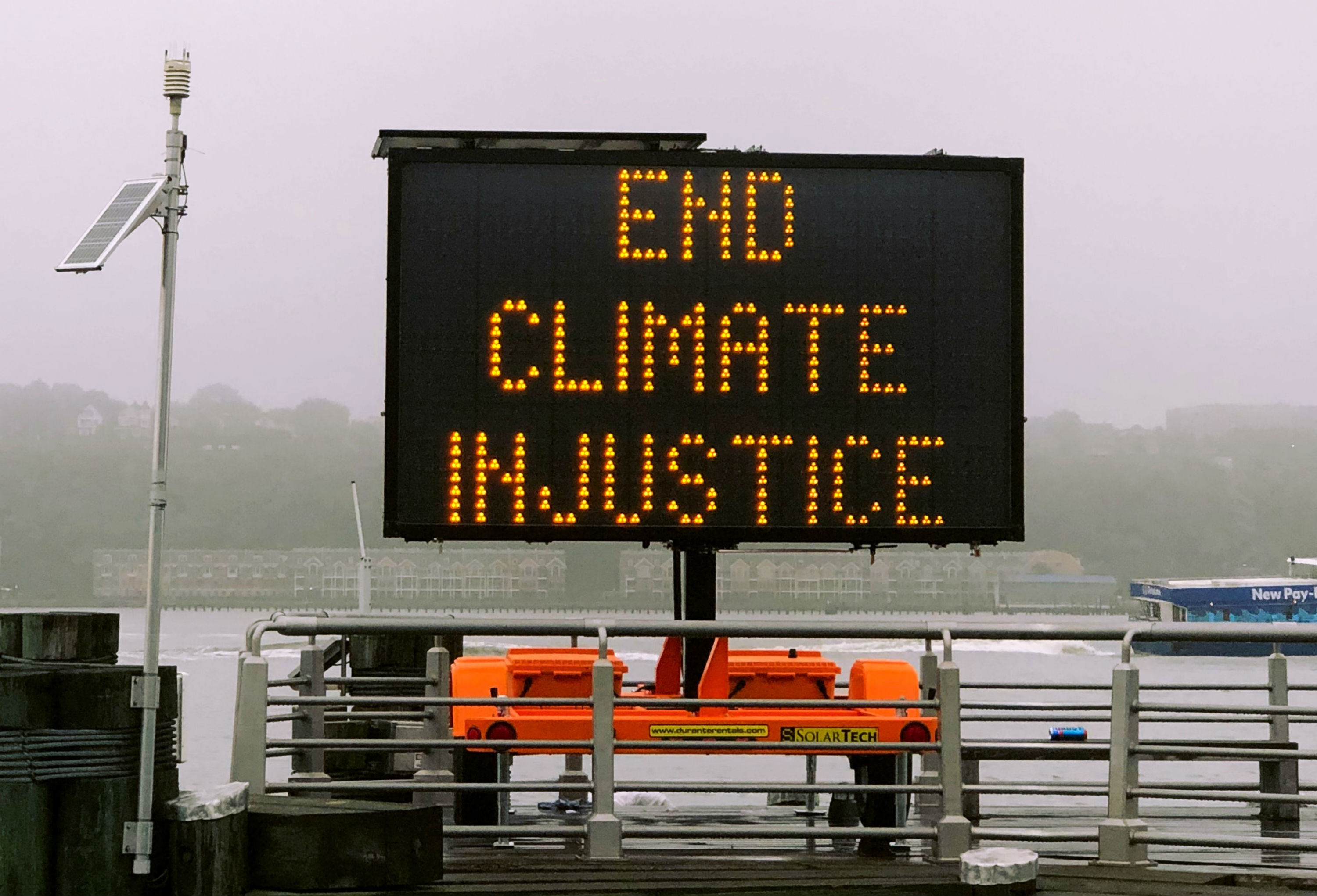 Una cartel pide el fin de la “injusticia climática” (Jon Tyson via Unsplash)