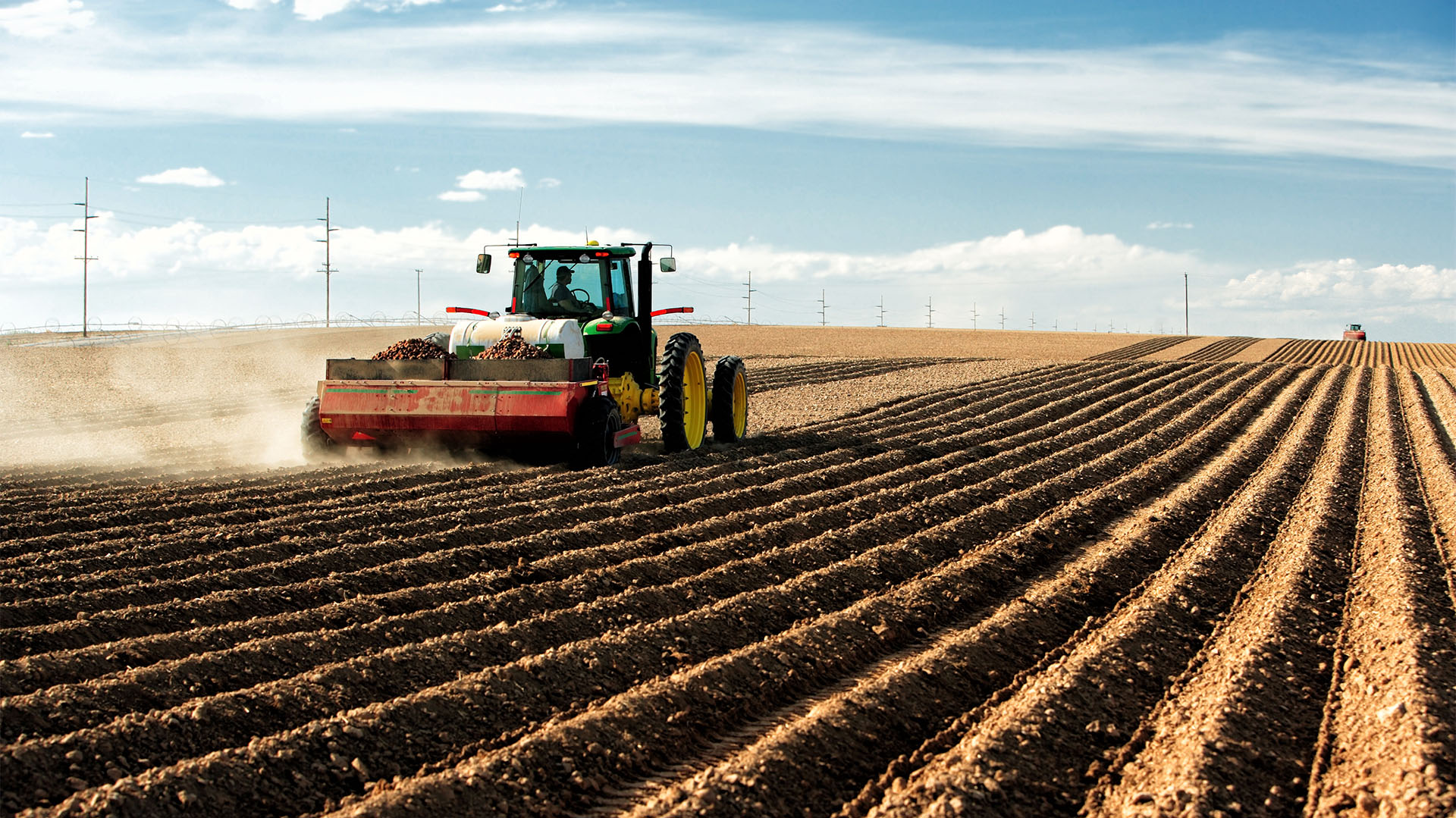Un agricultor usa un tractor y un implemento para plantar papas en los campos de cultivo de Idaho (Shutterstock)