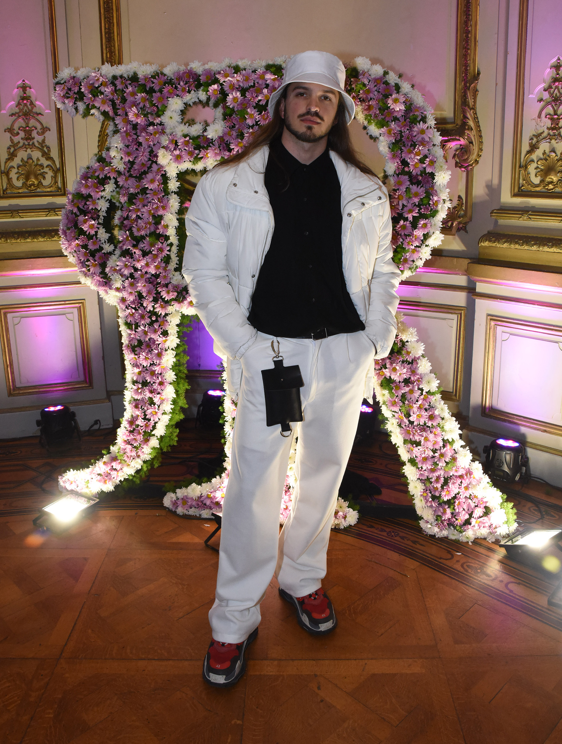 El diseñador Juan Sartor, ex participante del concurso Corte y Confección lució un conjunto de pantalón blanco, camisa y campera “puffer jacket” en blanca. Completó su look con el gorro tendencia, el gorro piluso