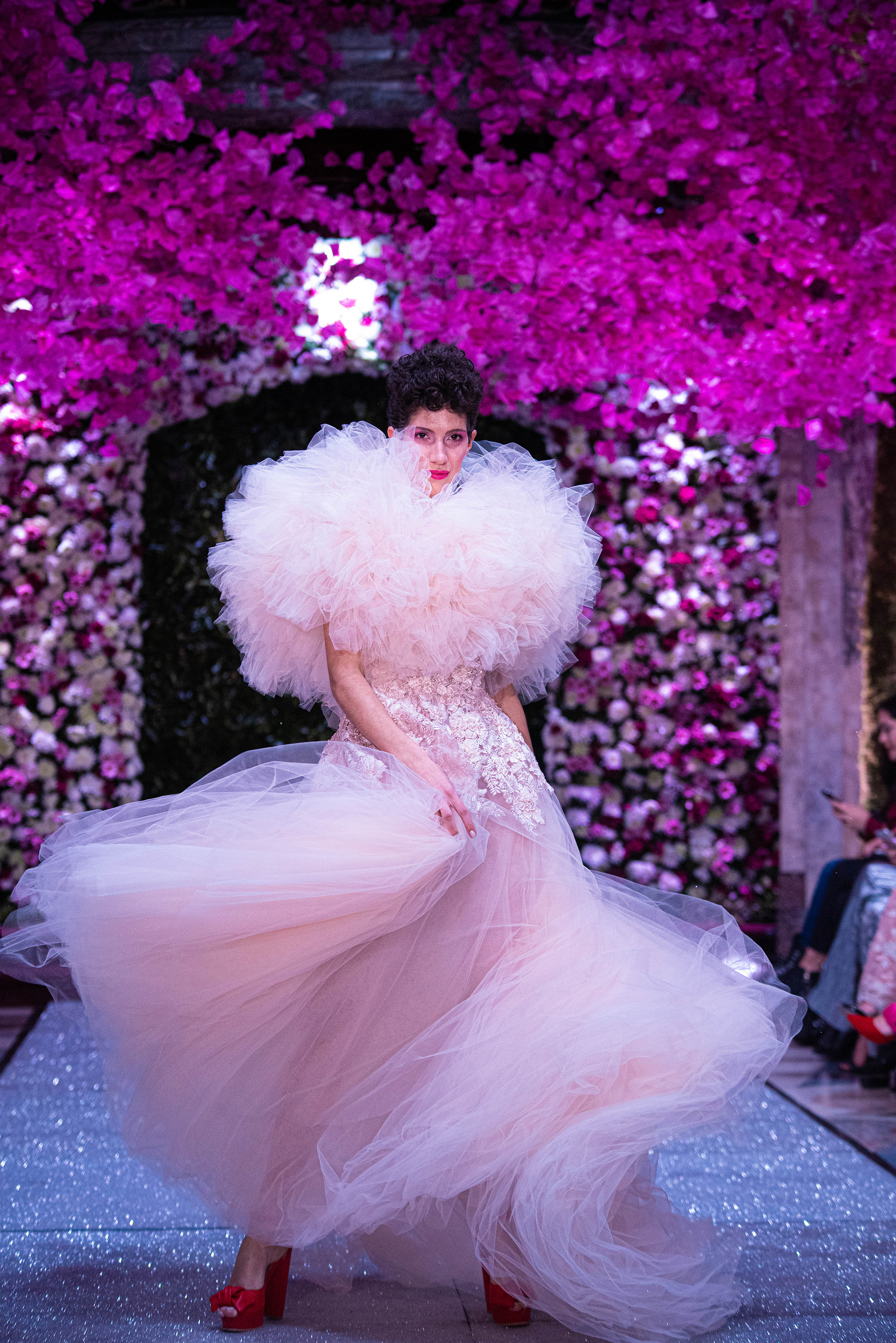 El diseñador se caracteriza por sus diseños realizados en tul, sedas y bordados. En pasarela, un vestido con volumen en el cuello confeccionado en tul rosa