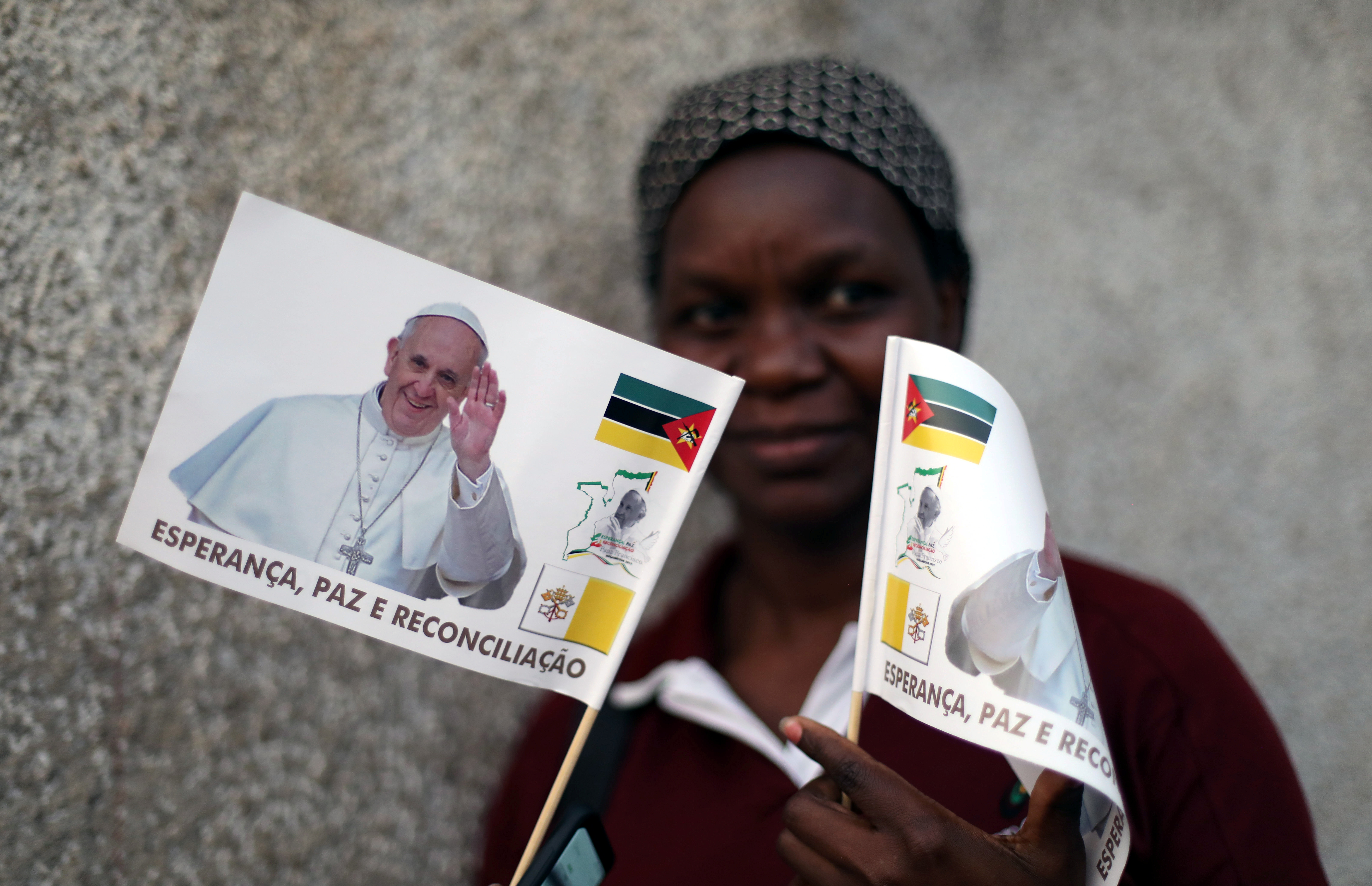 Una mujer flamea banderas con el rostro del Papa en Maputo (Reuters)