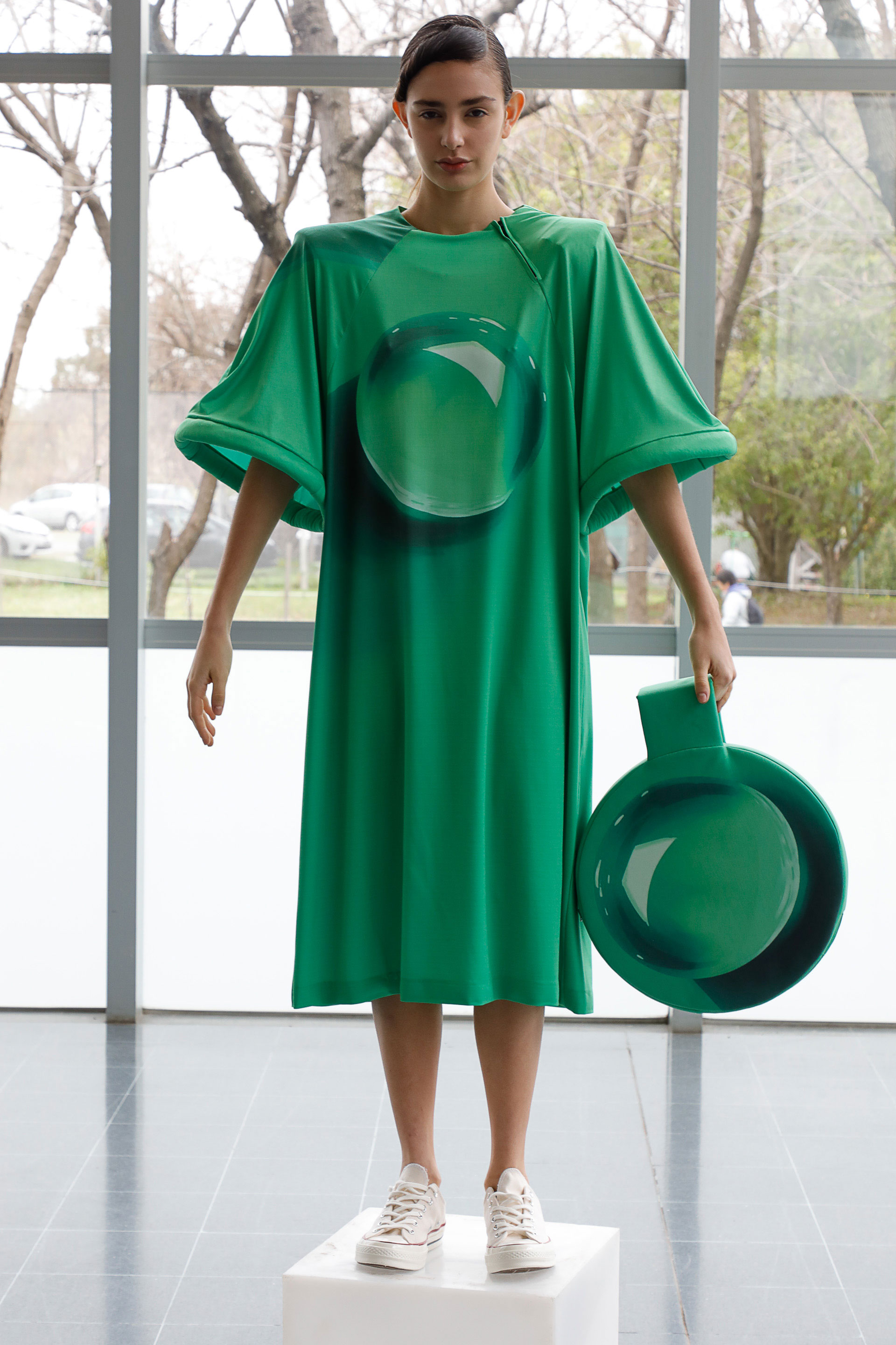 Vestido en verde esmeralda con mangas campana y clutch en forma circular, la propuesta de Nous Etudions en el Día Sustentable de Moda