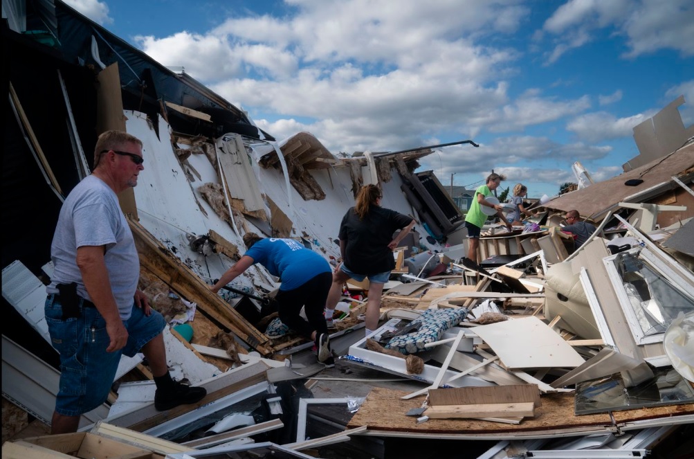 Vecinos ayudan a la propietaria Tamara Briley, en el centro, a salvar artículos de su casa móvil, después de que un tornado provocado por el huracán Dorian destruyera el inmueble en Boardwalk RB Part, en Isla Emerald, Carolina del Norte (Foto: Elijah Nouvelage/The Washington Post)