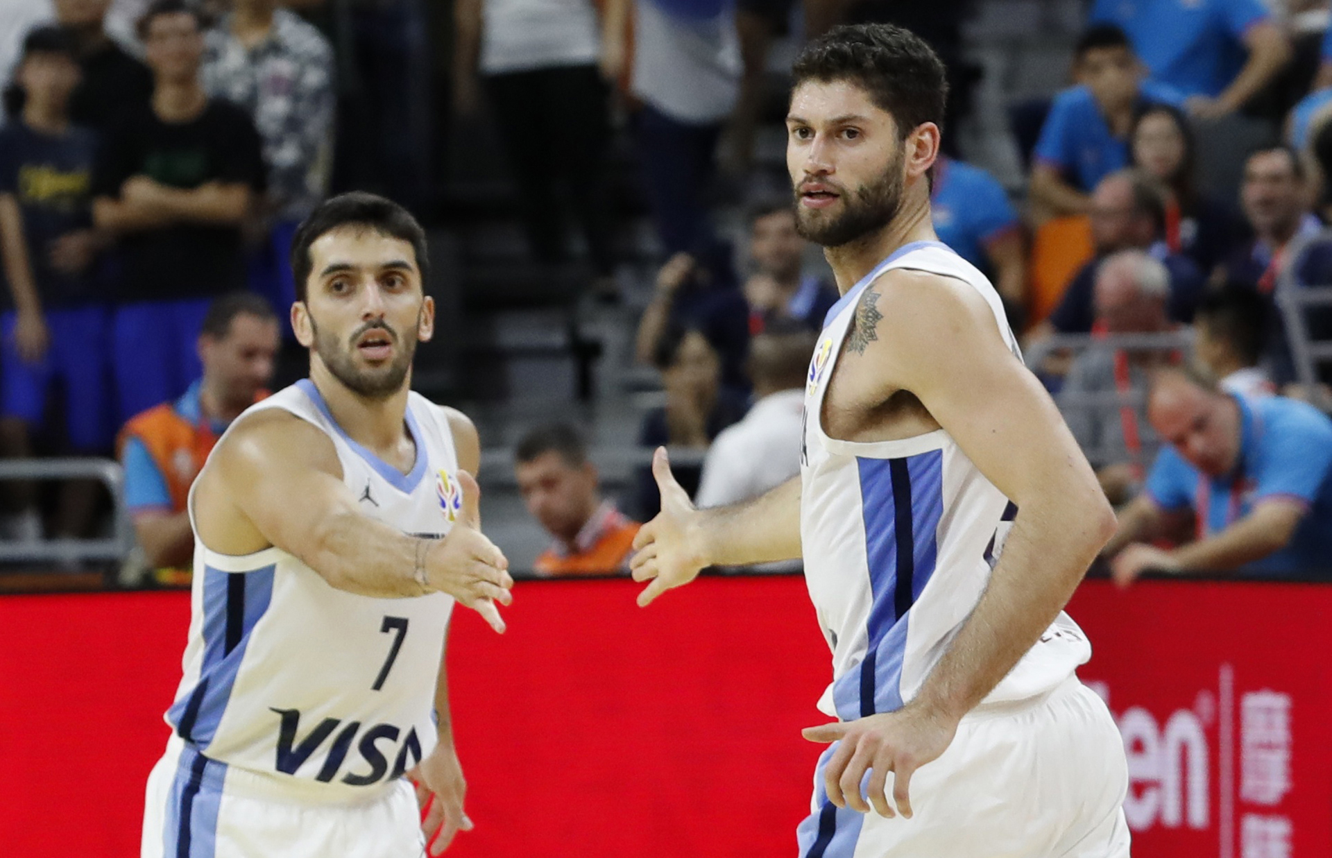 Facundo Campazzo choca las manos con Patricio Garino