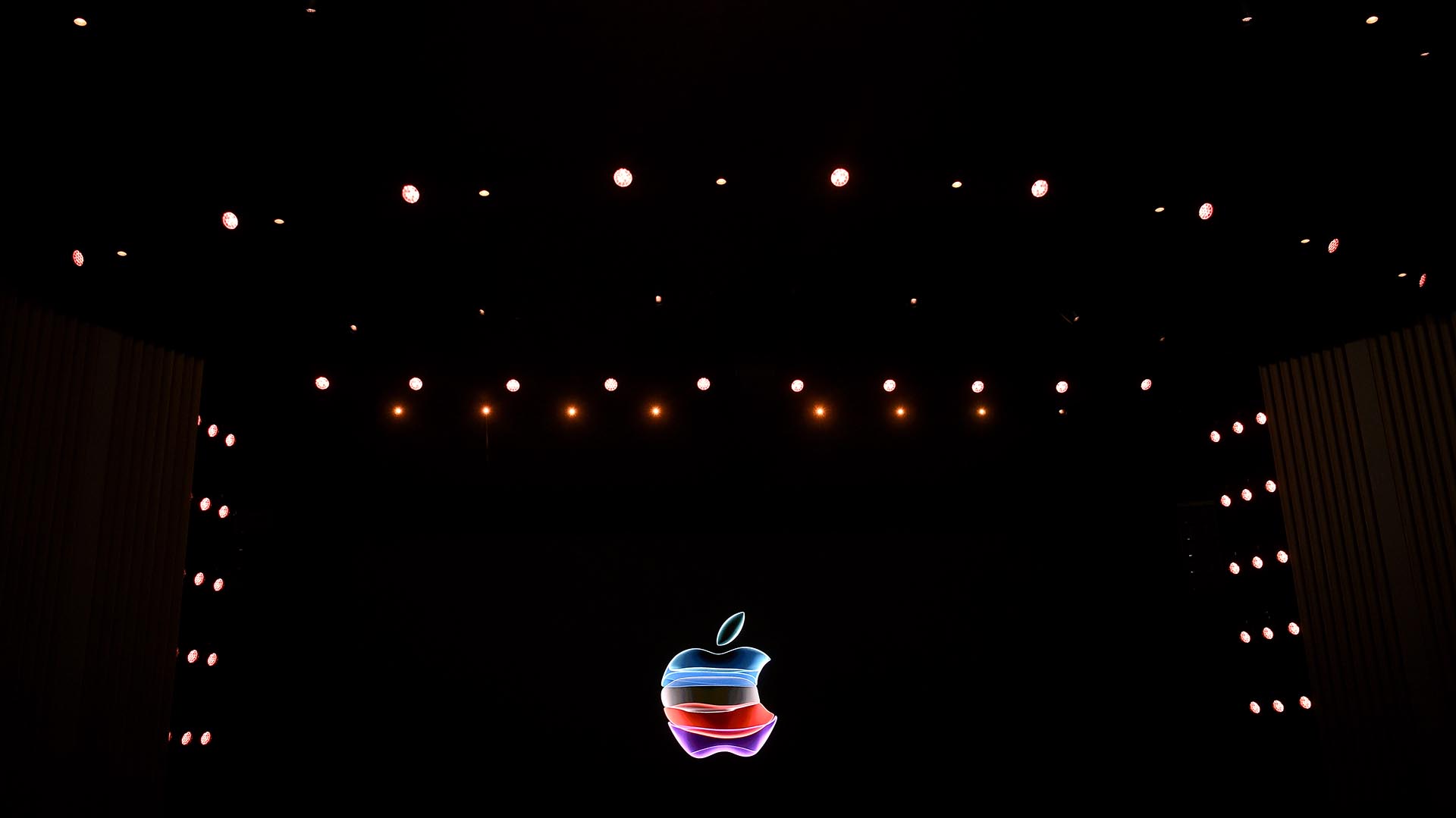 El logotipo de la manzana se proyecta en una pantalla antes del inicio del Apple Special Event (Photo by Josh Edelson / AFP)