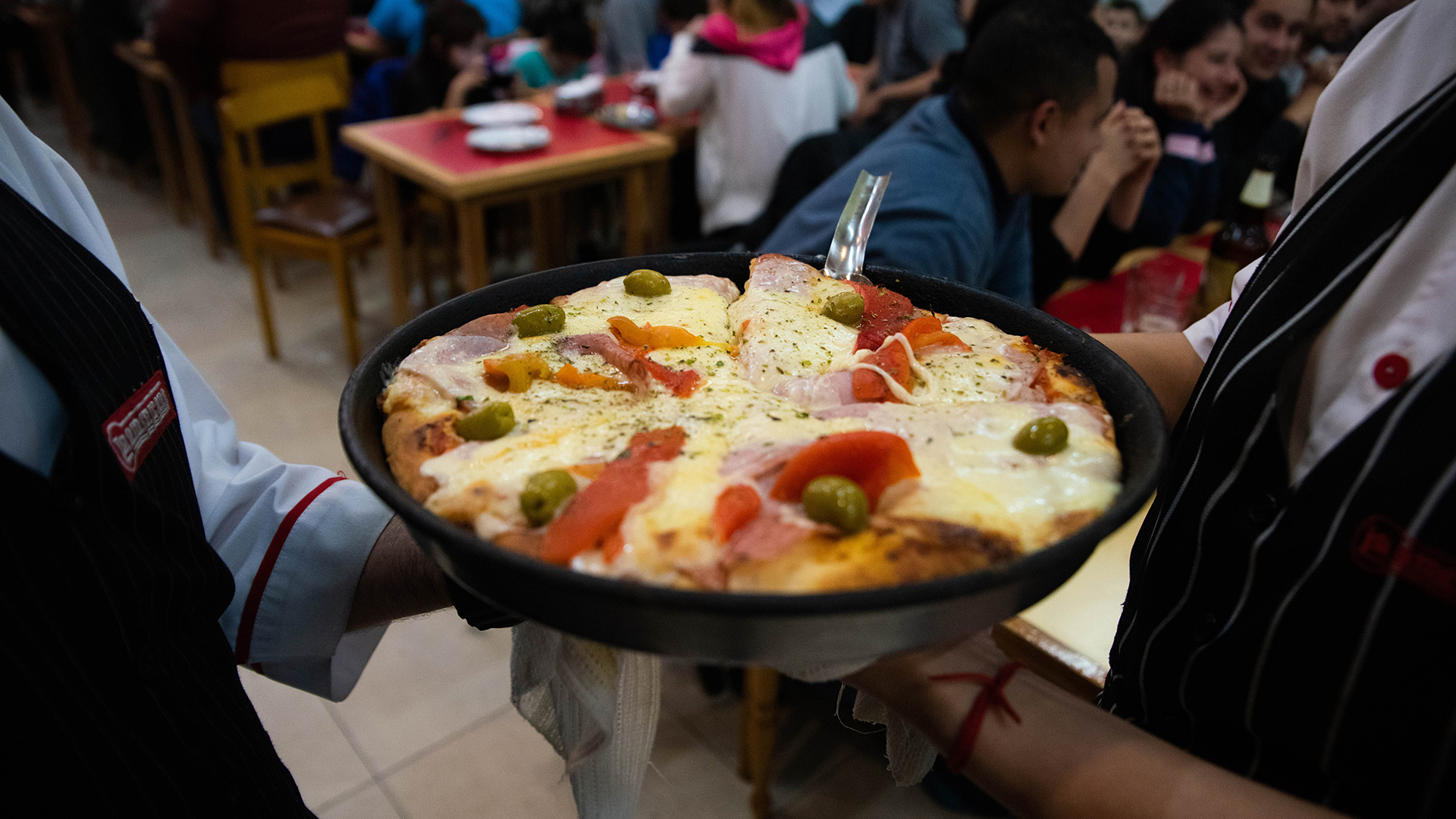 A punto de ser servida a los comensales. Una pizza grande de jamón y morrones, una clásica de La Americana