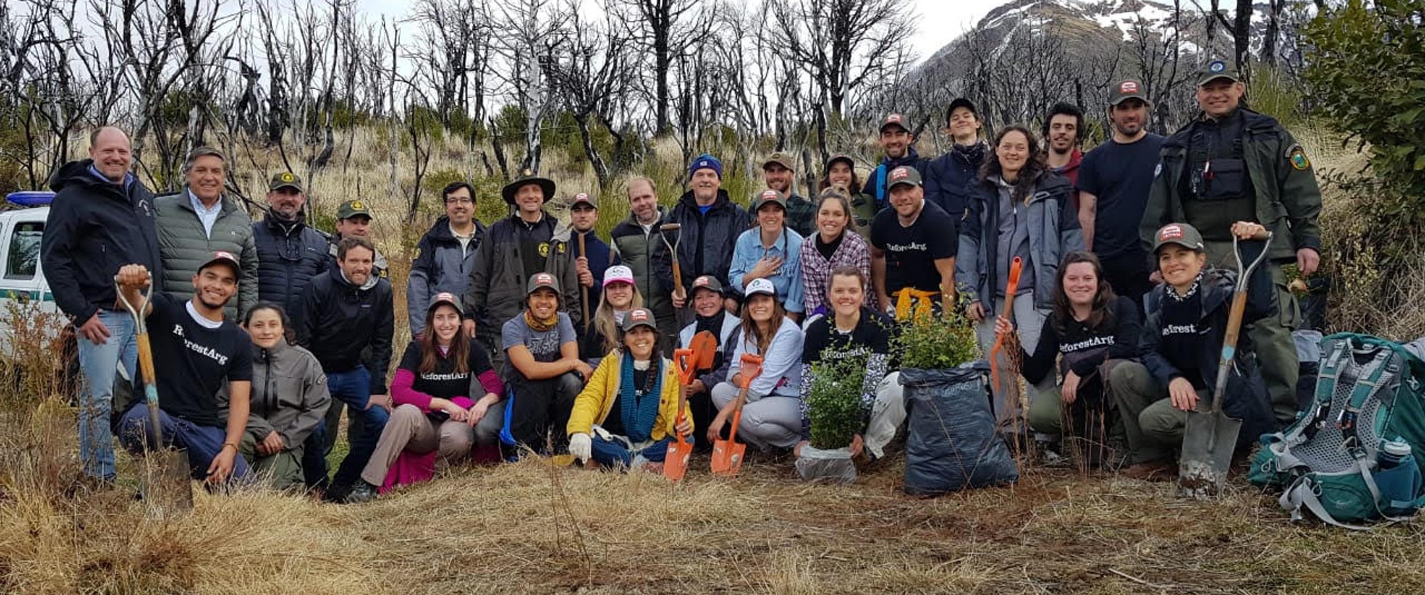 Un grupo de voluntarios que se encuentra plantando árboles en el Parque Los Alerces