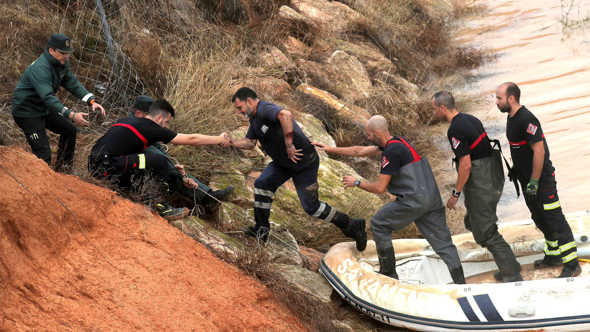 Socorristas ayudan a un hombre que quedó varado dentro de un túnel inundado tras las fuertes lluvias en Pilar de la Horadada (REUTERS/Sergio Pérez)