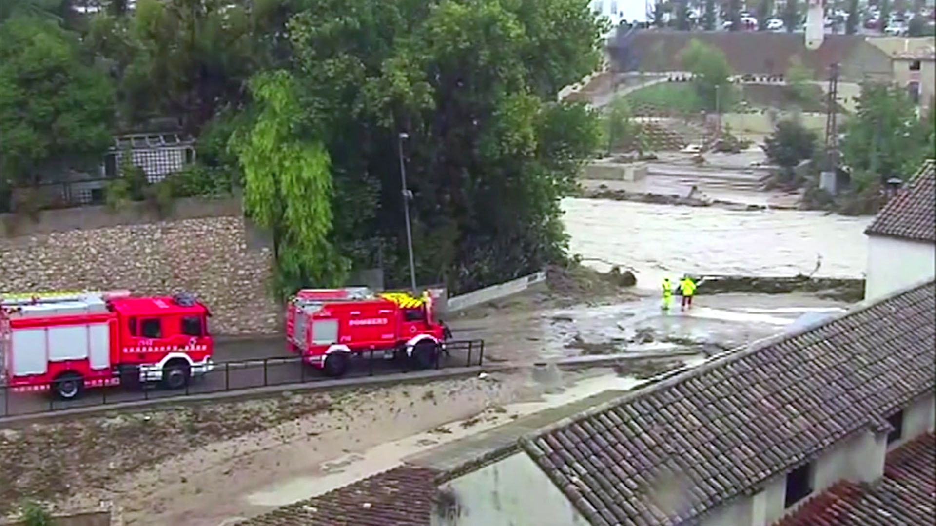 Camiones de bomberos conducen por un río inundado, en Ontiyente, España, el jueves 12 de septiembre (Atlas vía AP)