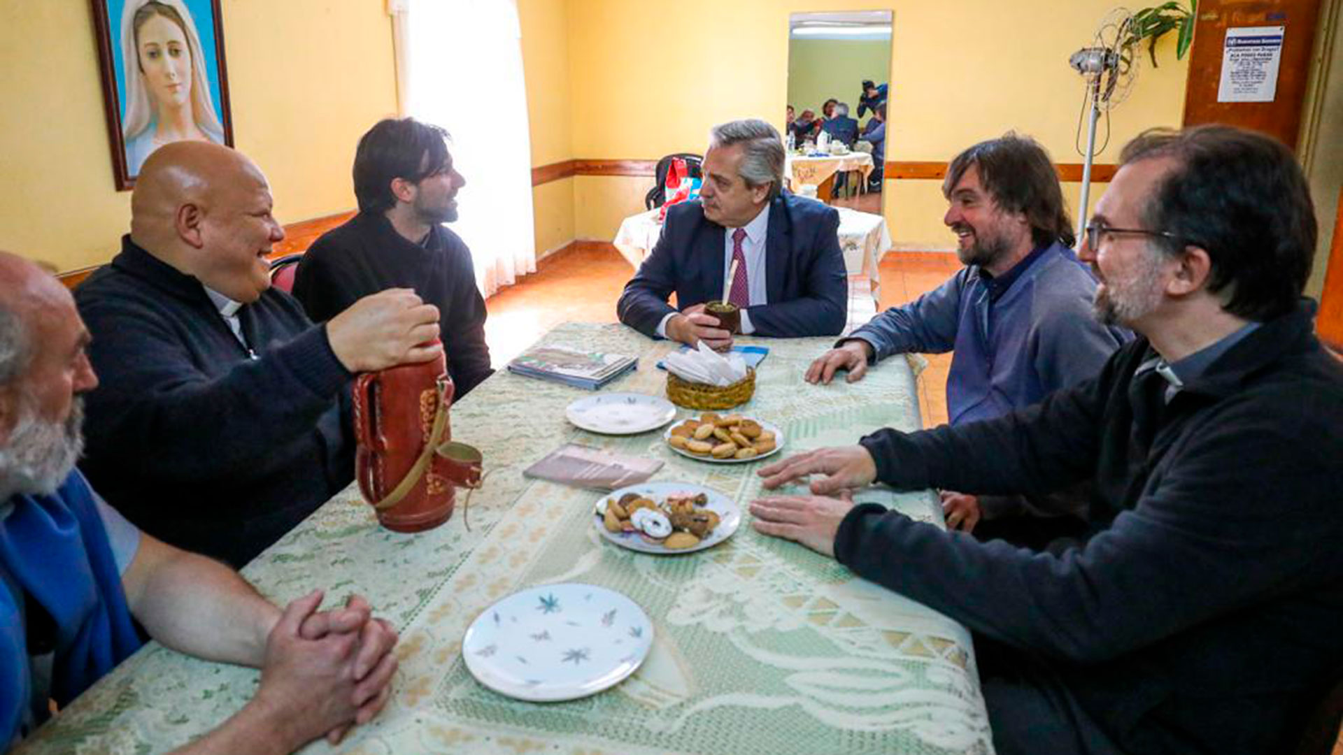 Mate y masitas en la charla de Fernández con los curas villeros. En el espejo, la imagen de Cafiero
