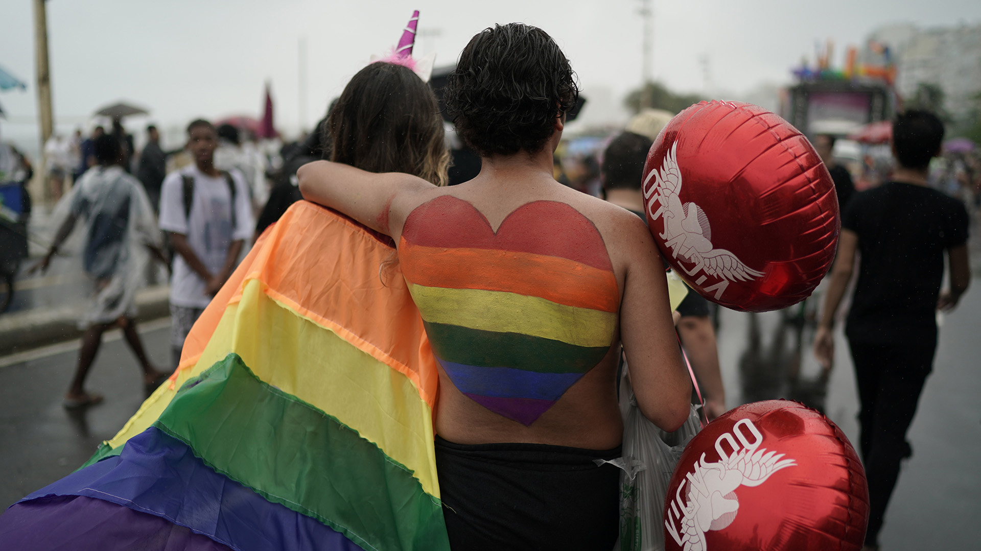 Las personas asisten al desfile anual del orgullo gay a lo largo de la playa de Copacabana. (Foto AP / Leo Correa)