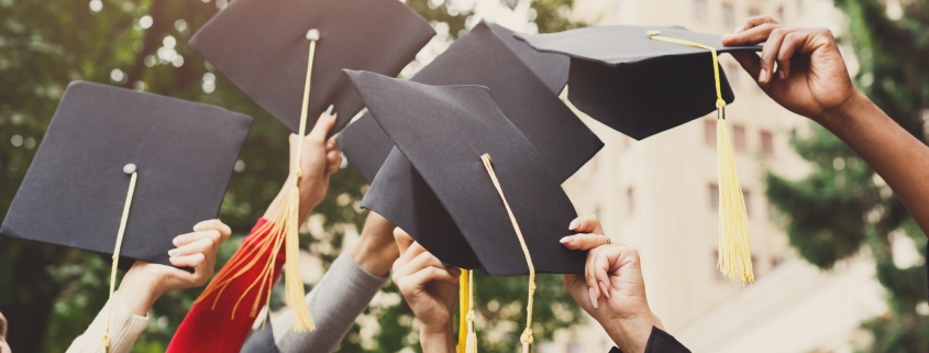 A group of graduates throwing graduation caps in the air