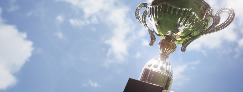 Holding up a trophy cup as a winner