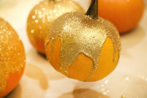 Adding glitter to paint dipped pumpkin