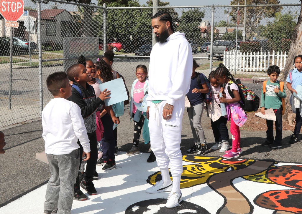 Nipsey Hussle greets kids at the Nipsey Hussle x PUMA Hoops Basketball Court Refurbishment Reveal Event on Oct. 22, 2018, in Los Angeles. Photo: Getty Images for PUMA Jerritt Clark