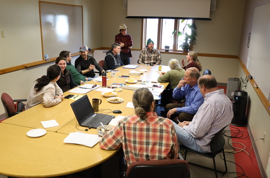 A photograph of people at a meeting, sharing information.