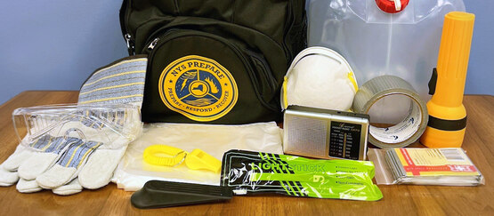 A collection of emergency items including gloves, eye protection, a face mask, tape, a flashlight, and more.