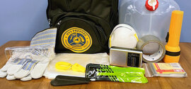 A collection of emergency items including gloves, eye protection, a face mask, tape, a flashlight, and more.