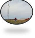 solar panels in foreground, wind turbines in middle ground, and the electric grid in the background