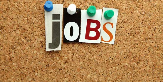 the word "jobs" spelled with push-pins and cut out letters on a cork bulletin board