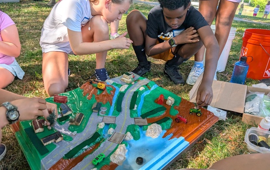 Campers learning about watersheds, pollution, and measures to limiting water pollution.