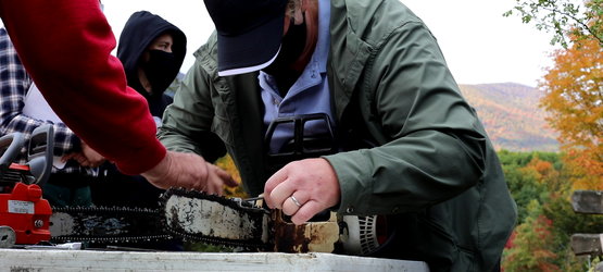 A woman sharpening a chainsaw